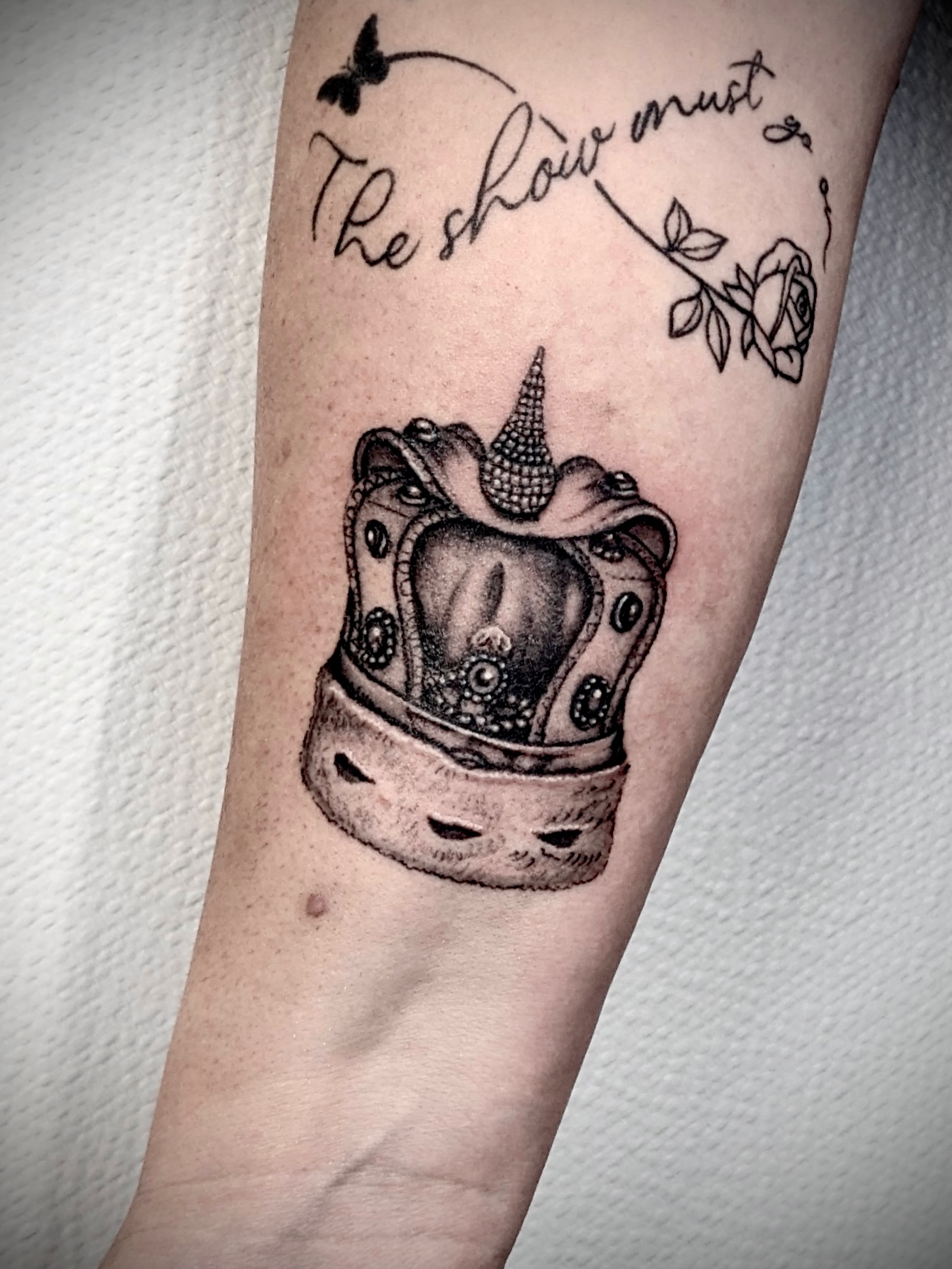 Crown black and grey tattoo on the forearm by Deborah