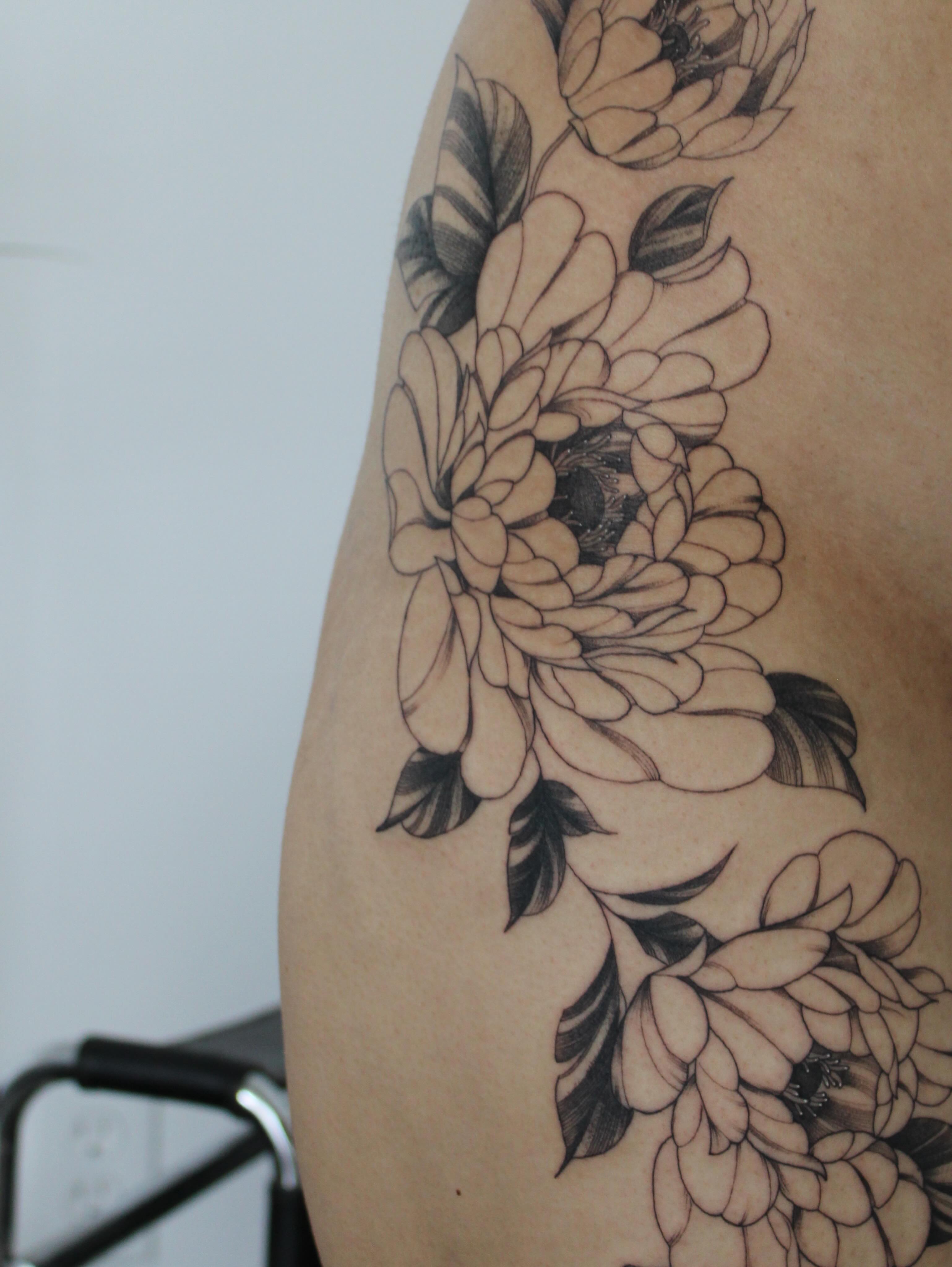 Floral arrangement black and grey tattoo on the thigh by Julianna