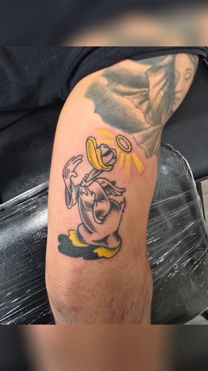 New school tattoo on the upper arm by Captain Michael Devious