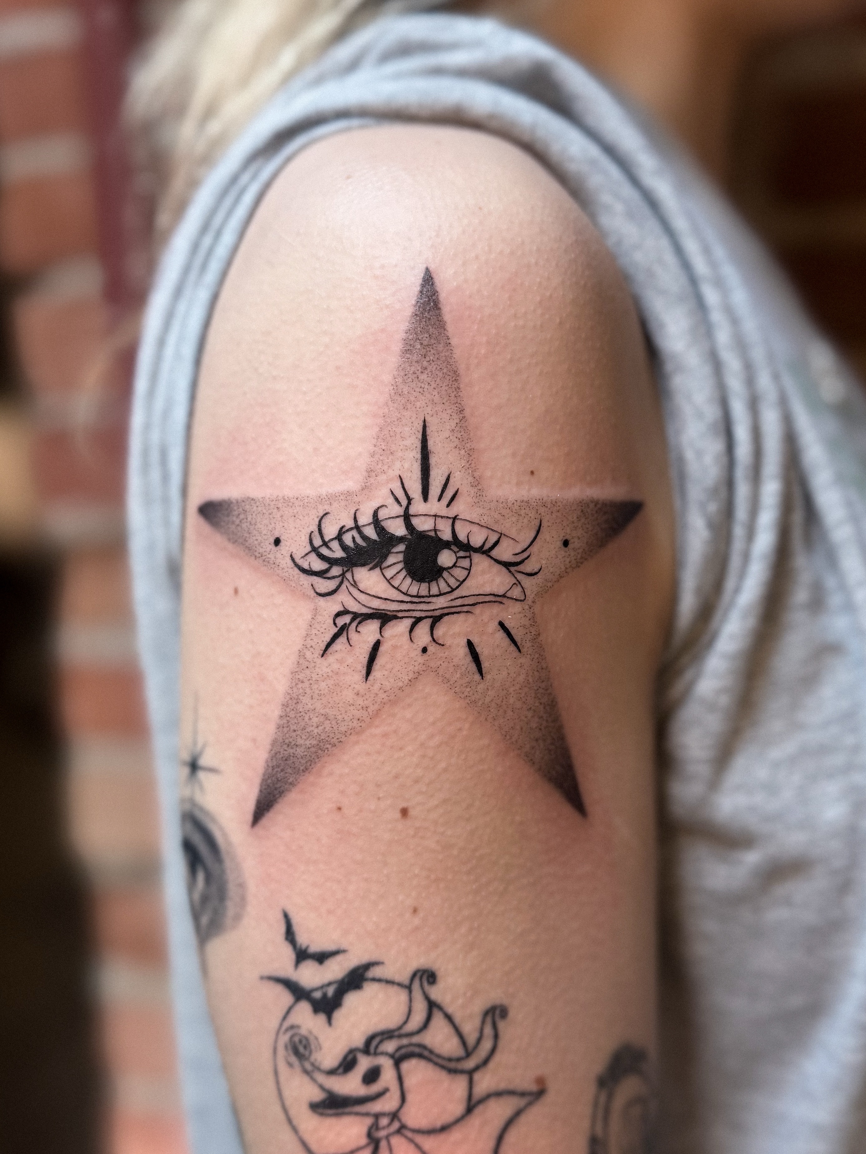 Eye within star dotwork tattoo on the shoulder by Jessica Bloom