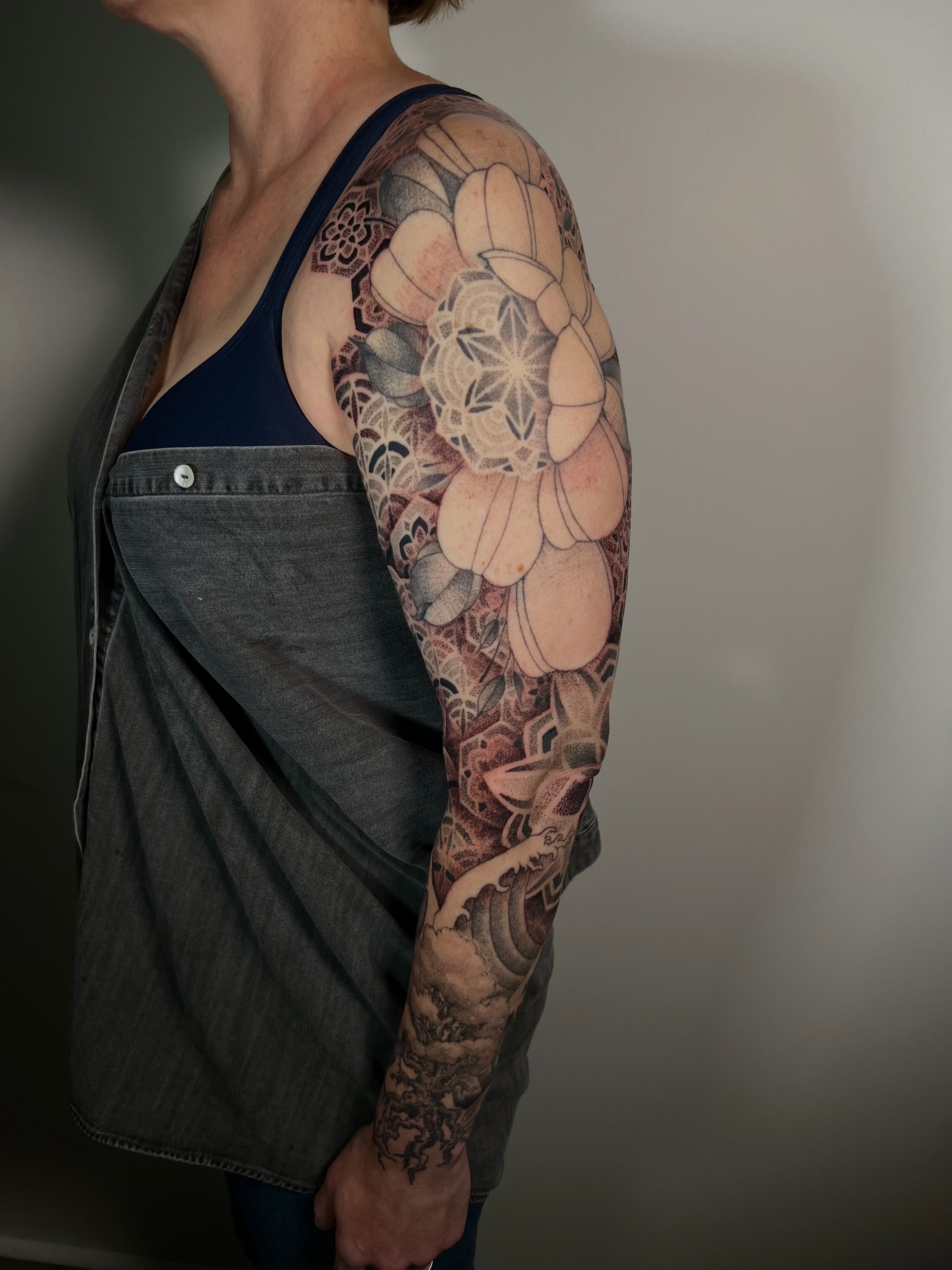 Lotus flower realism tattoo on the upper arm by Riley