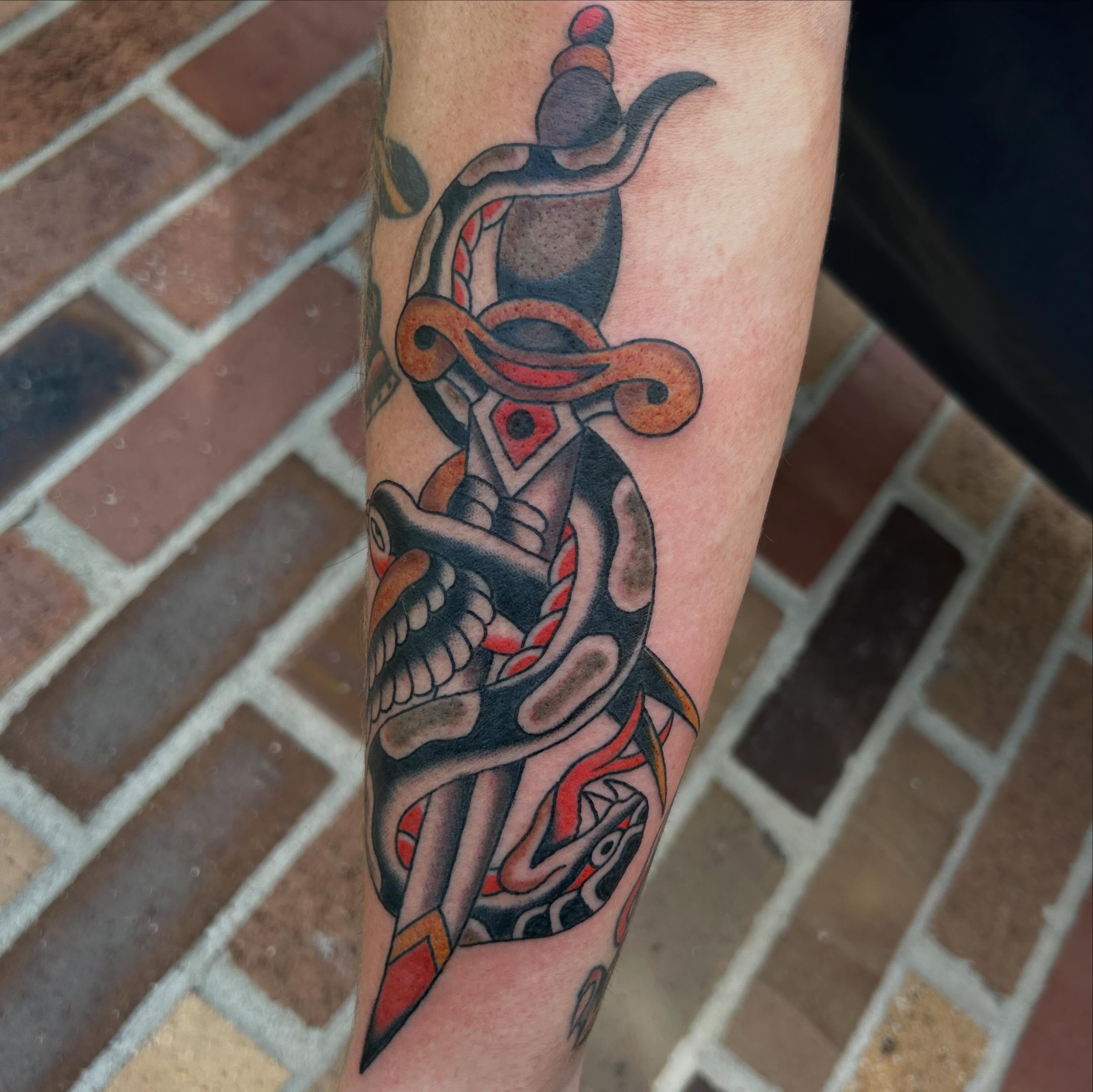 Serpent and dagger American traditional tattoo on the forearm by Donny