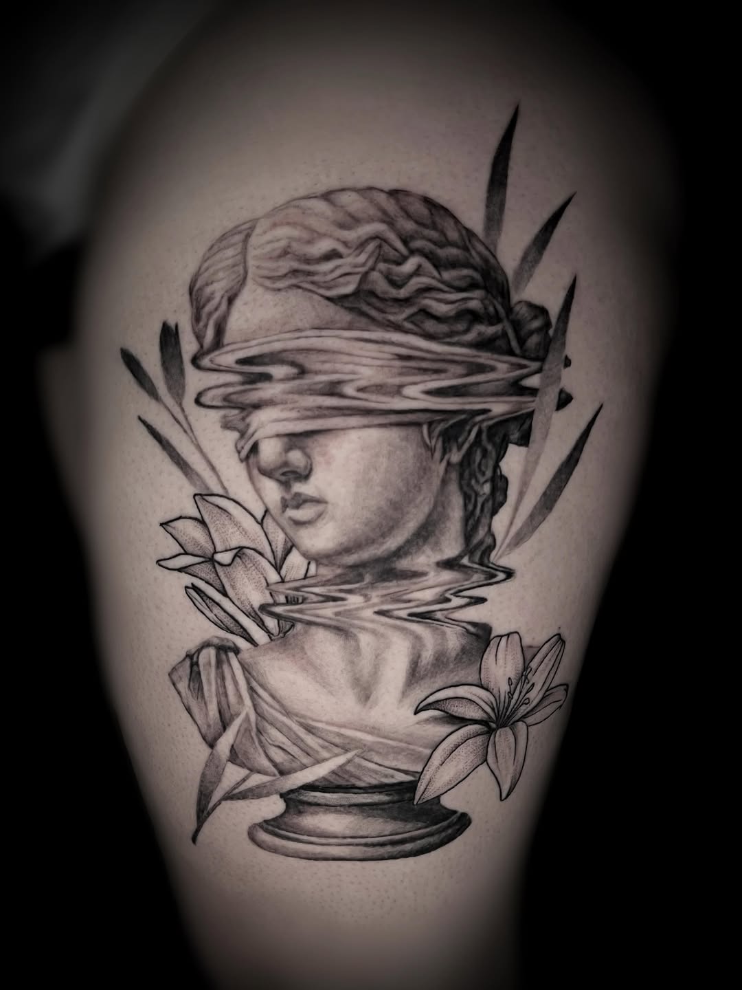 Blindfolded statue bust with flowers surrealism tattoo on the thigh by Saint