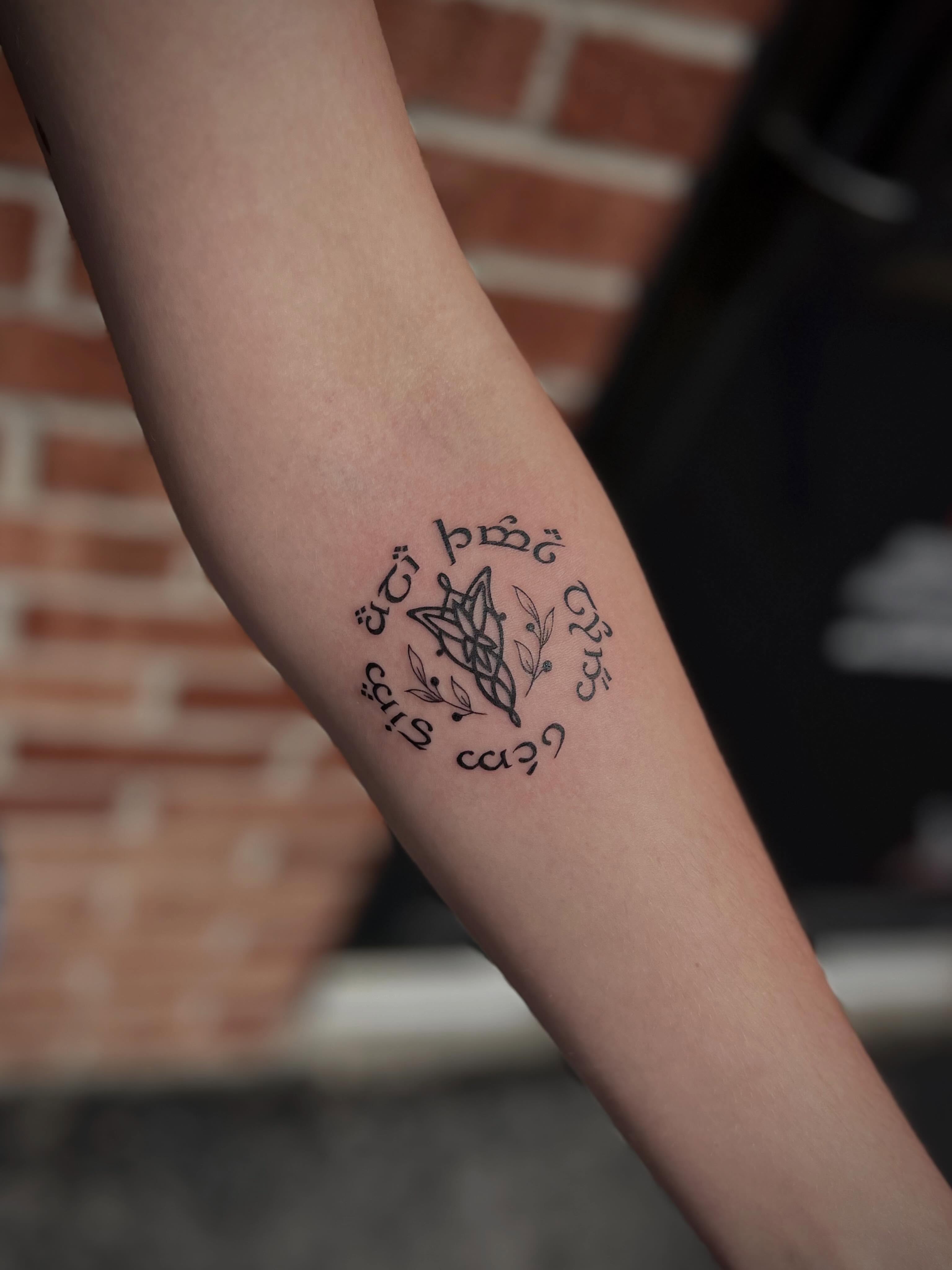 Geometric symbol with text geometric tattoo on the forearm by Lexi Rose