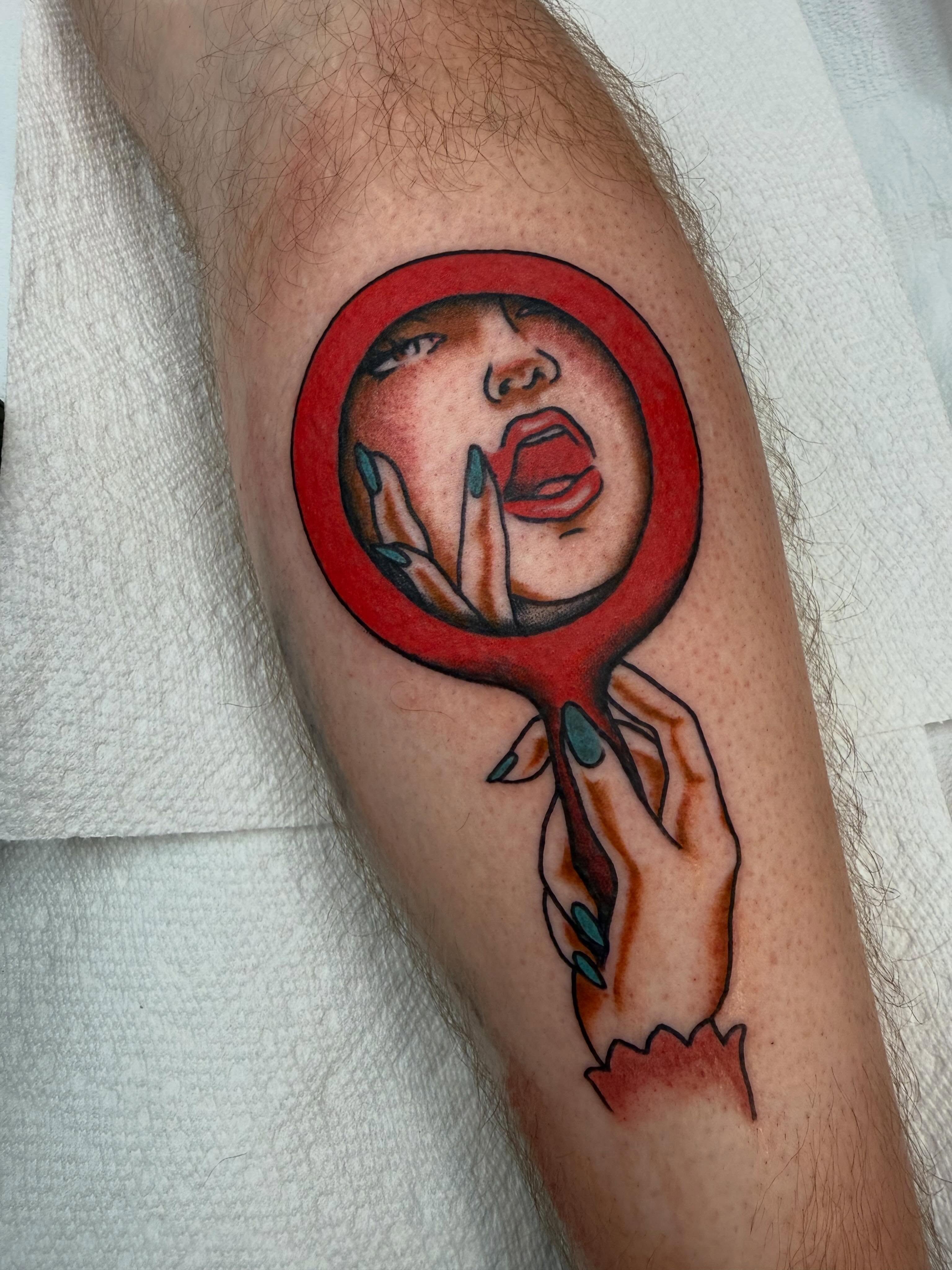 Woman's face through magnifying glass American traditional tattoo on the forearm by Mikaila Rose Krauss
