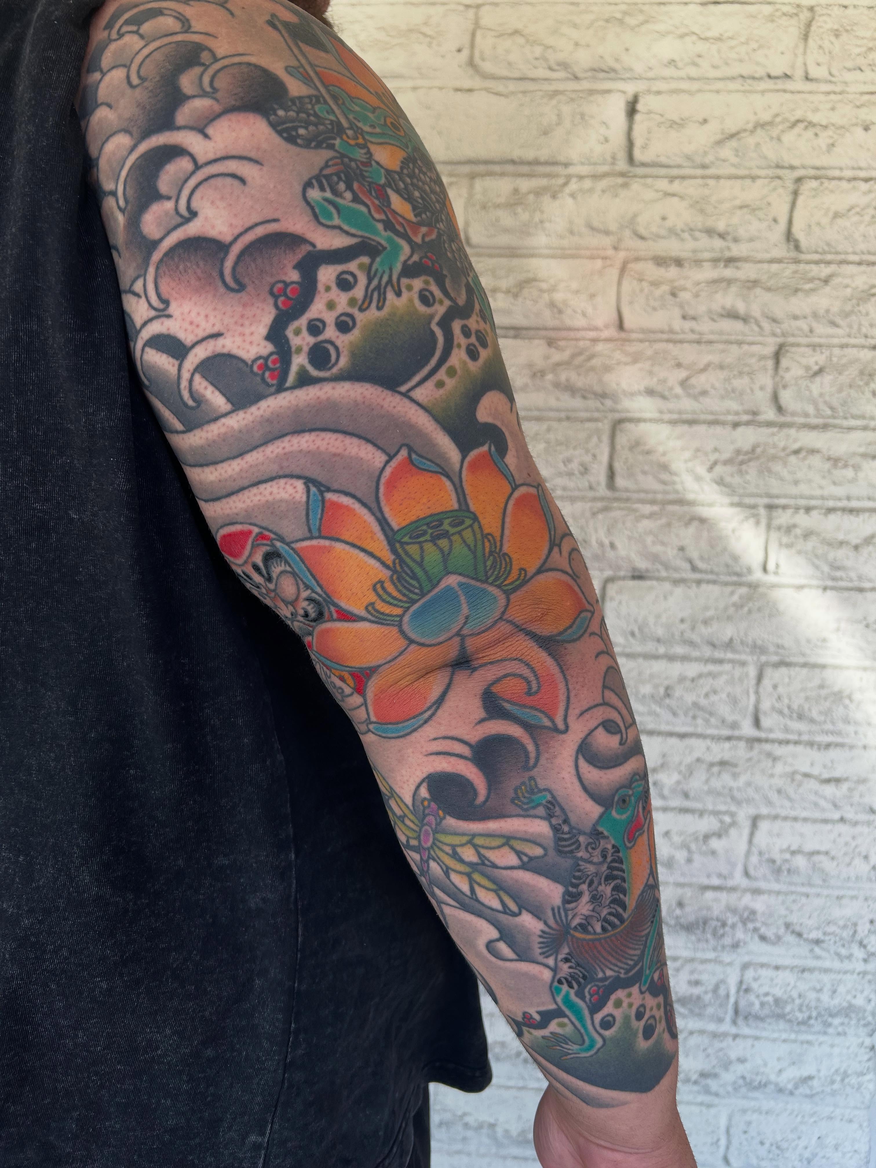 Lotus flower japanese irezumi tattoo on the upper arm by Stephen Sanchez