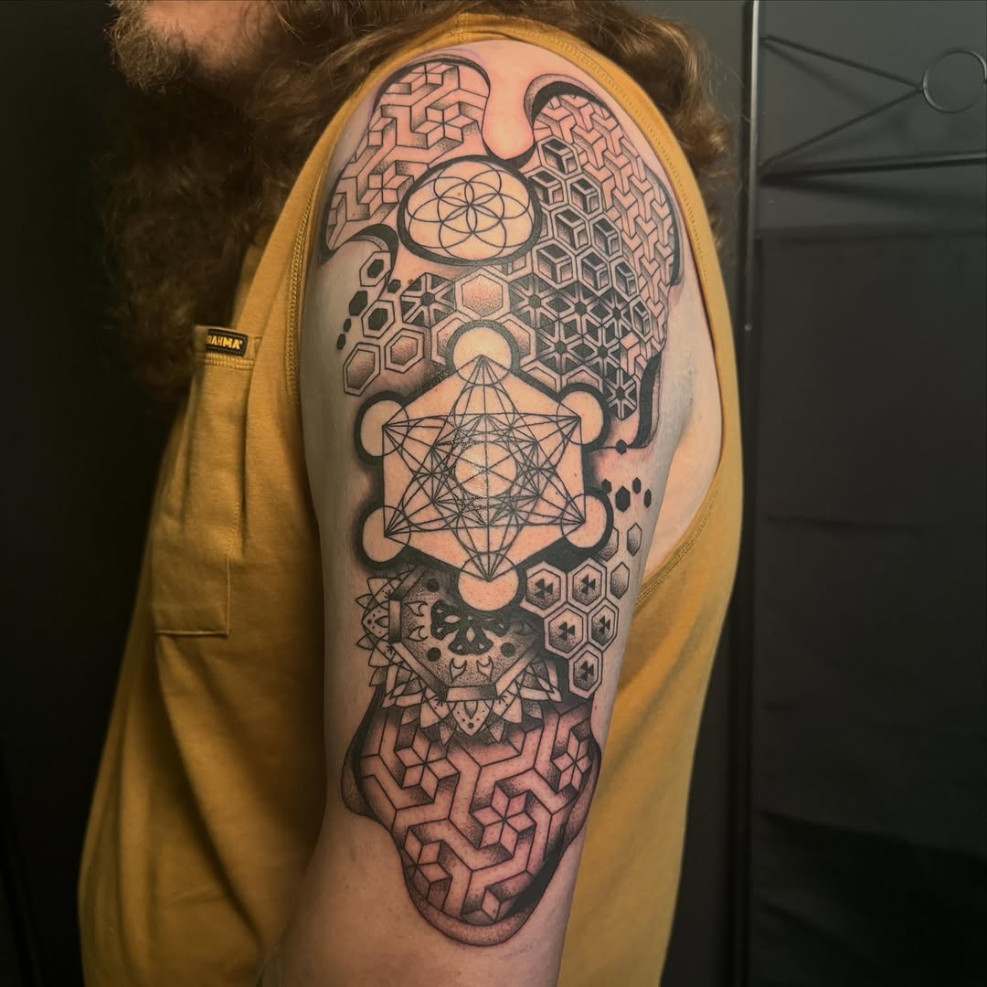 Geometric patterns and sacred geometry geometric tattoo on the upper arm by Scout Meyer