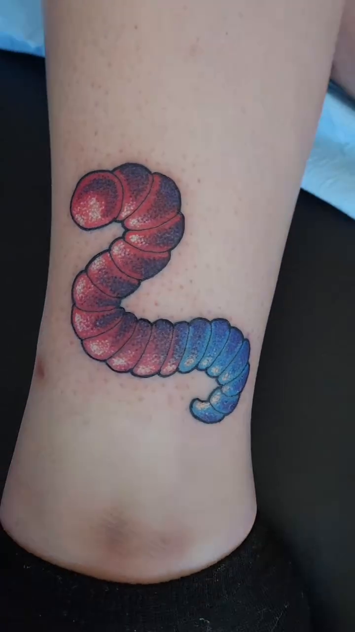 Gummy worm tattoo American traditional tattoo on the forearm by Randy