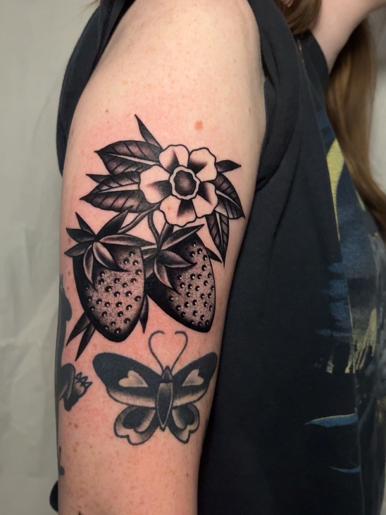 Strawberries and flower black and grey tattoo on the forearm by Chris Prince Jr., Miamisburg, Ohio