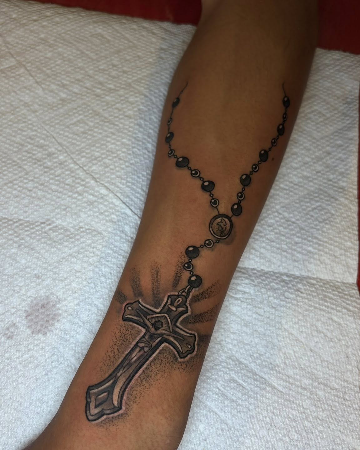 Rosary cross dotwork tattoo on the forearm by Joel Ortiz Ginorio