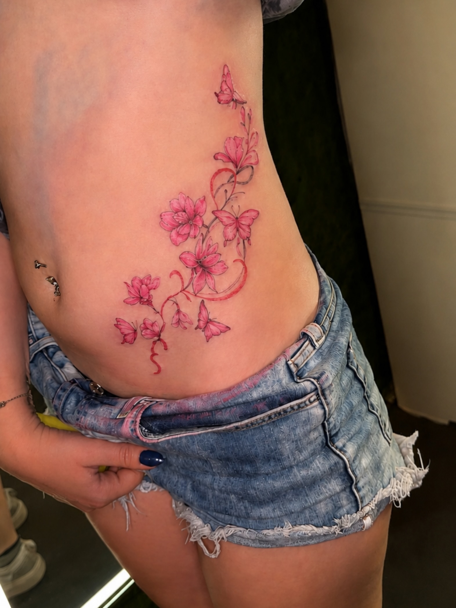Cherry blossoms and butterflies new school tattoo on the ribs by Cece, Las Vegas, Nevada