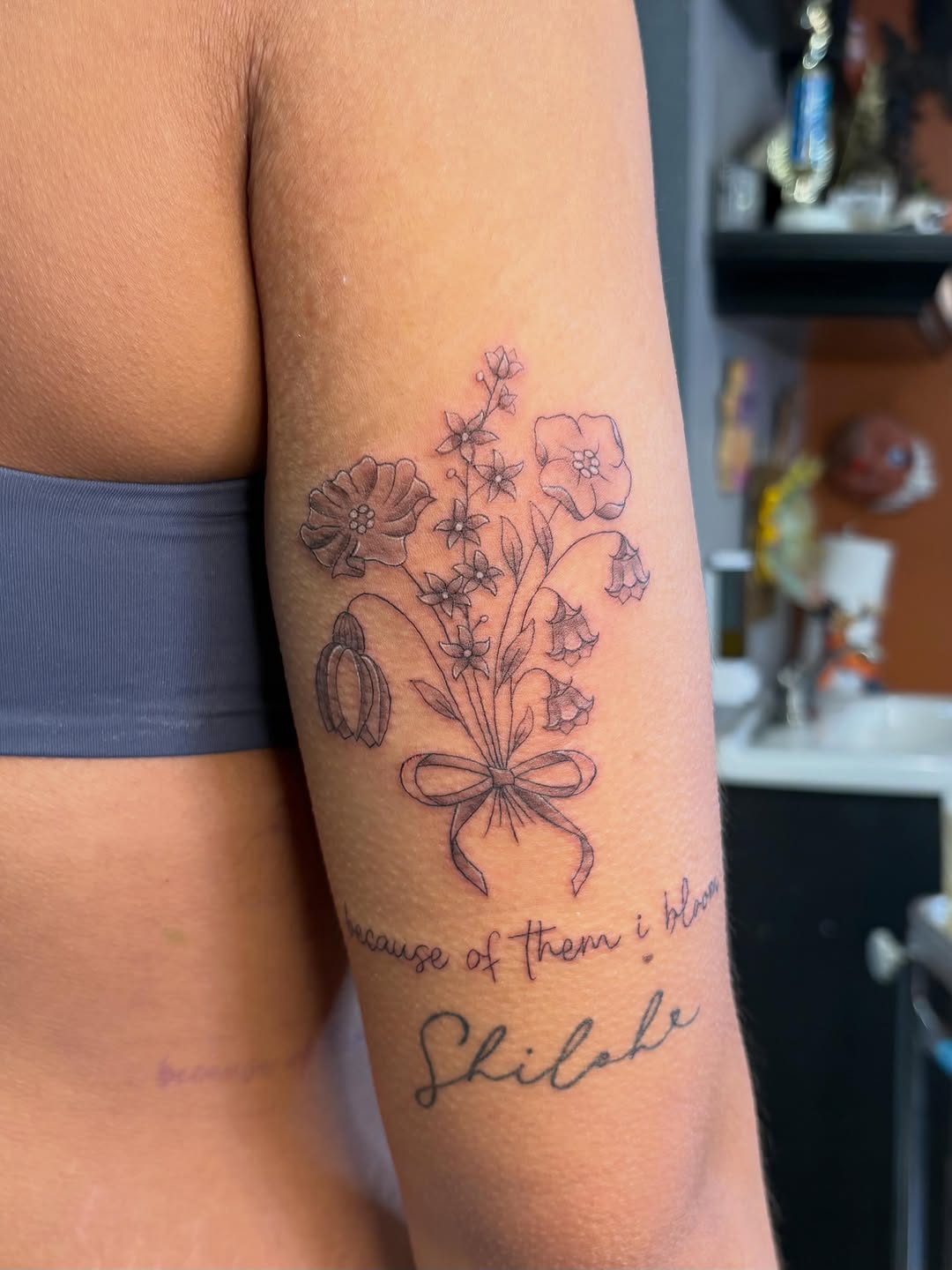 Bouquet of flowers and script minimalist tattoo on the forearm by alana khounmeuang