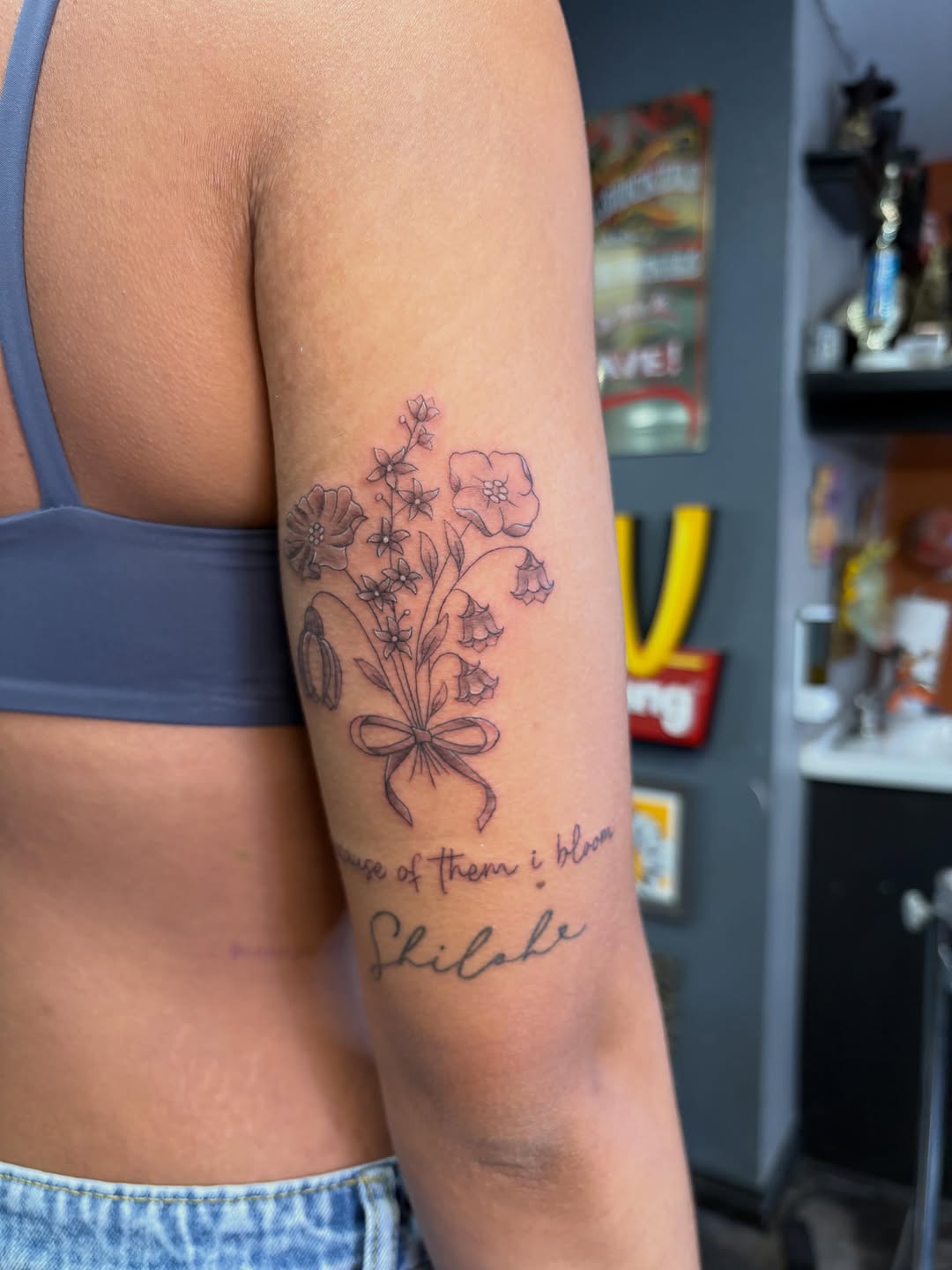 Bouquet of flowers and script minimalist tattoo on the forearm by alana khounmeuang