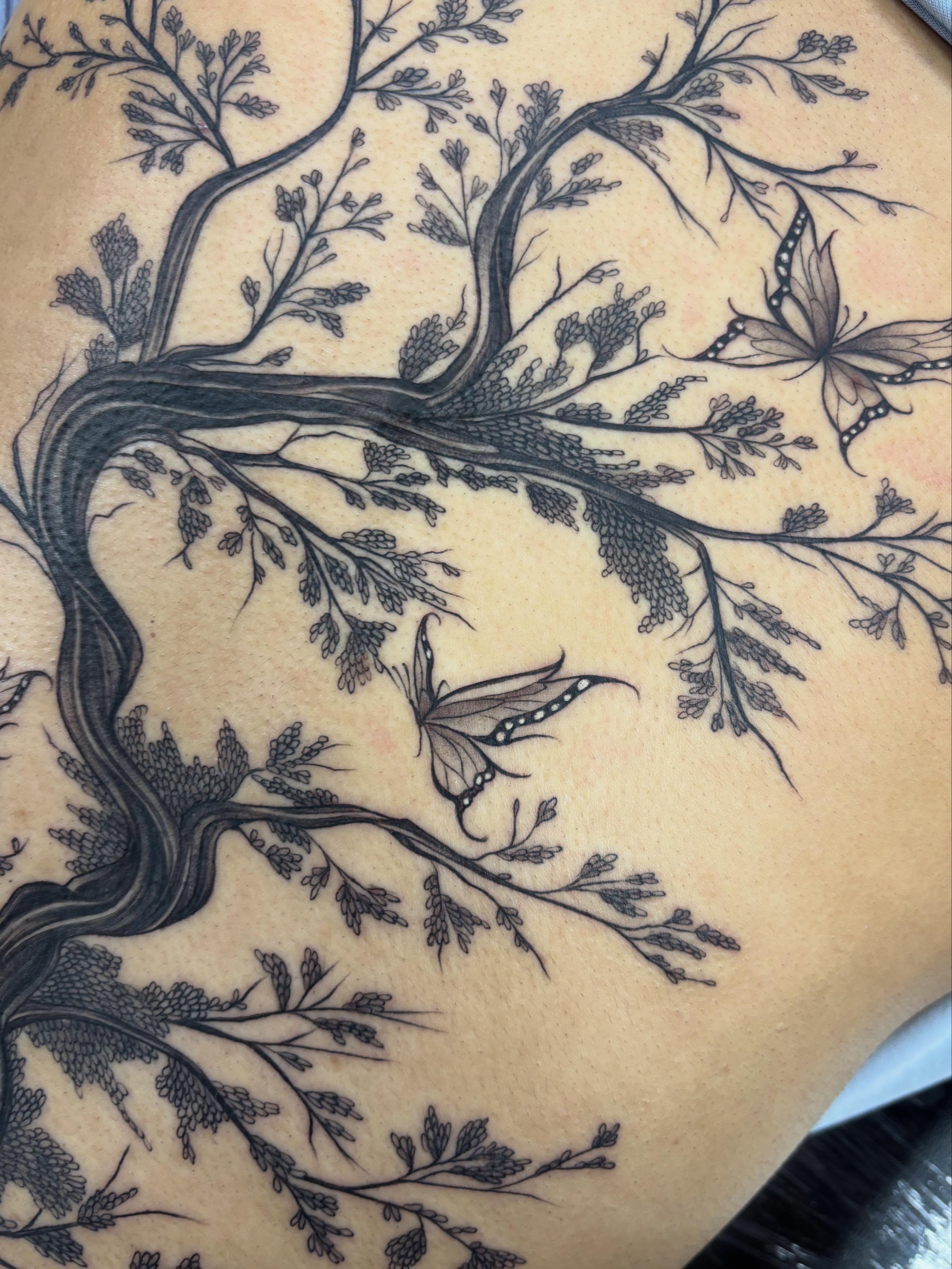 Tree with butterflies black and grey tattoo on the thigh by Jennifer Flores