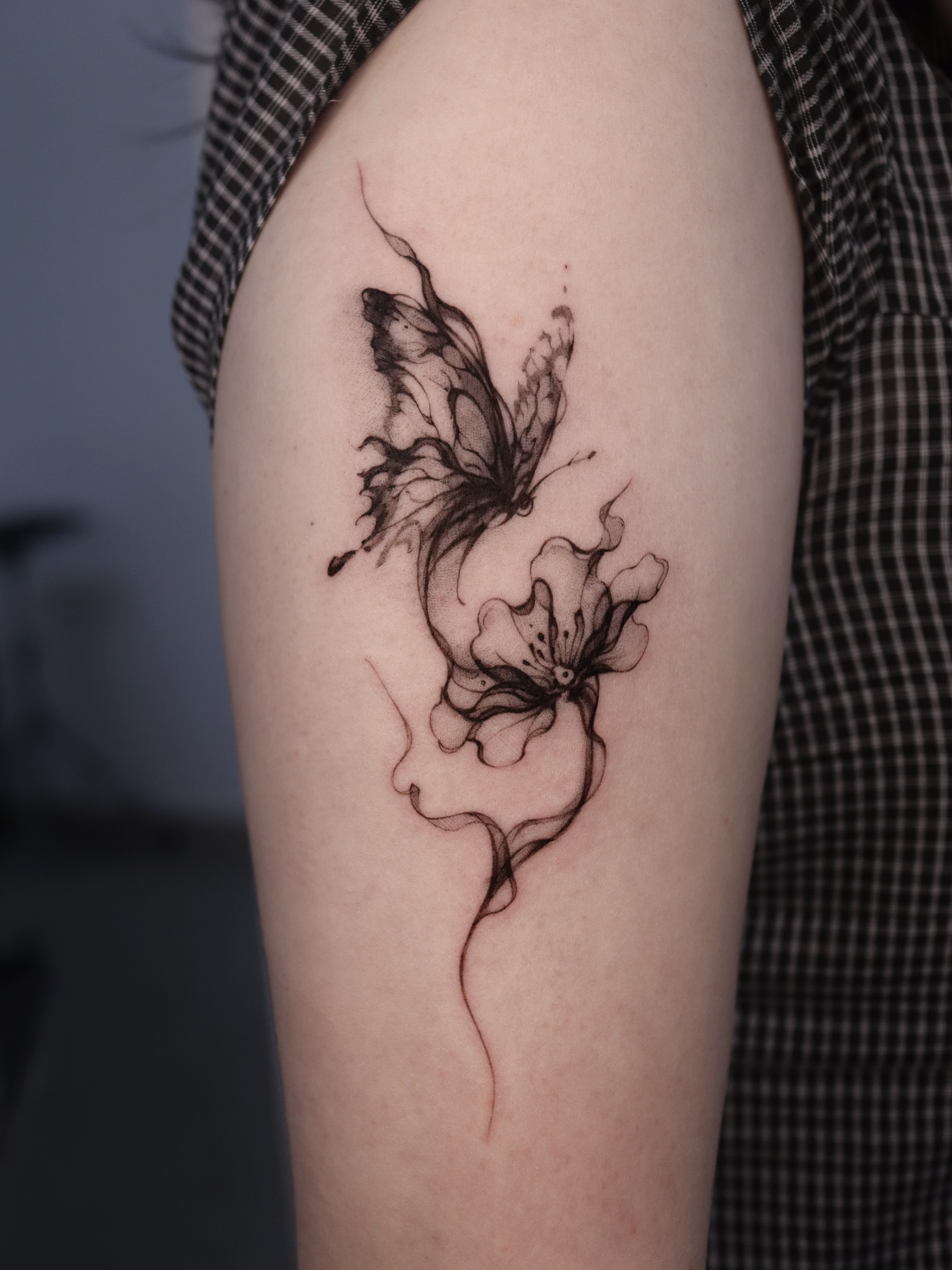 Butterfly and flower realism tattoo on the upper arm by @tattoo_chamsae
