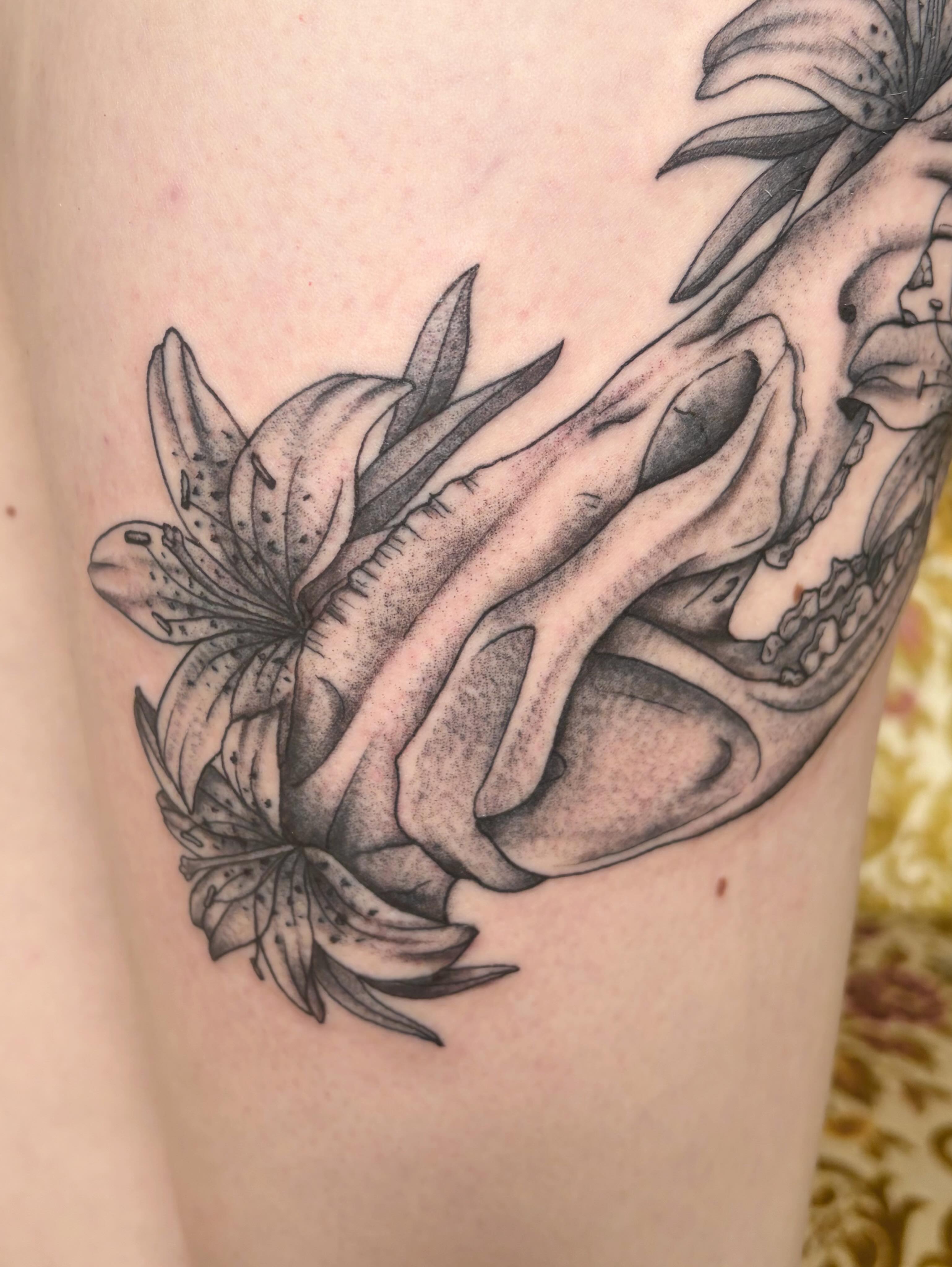Lily and skull realism tattoo on the thigh by Mary Hannah Sosdian