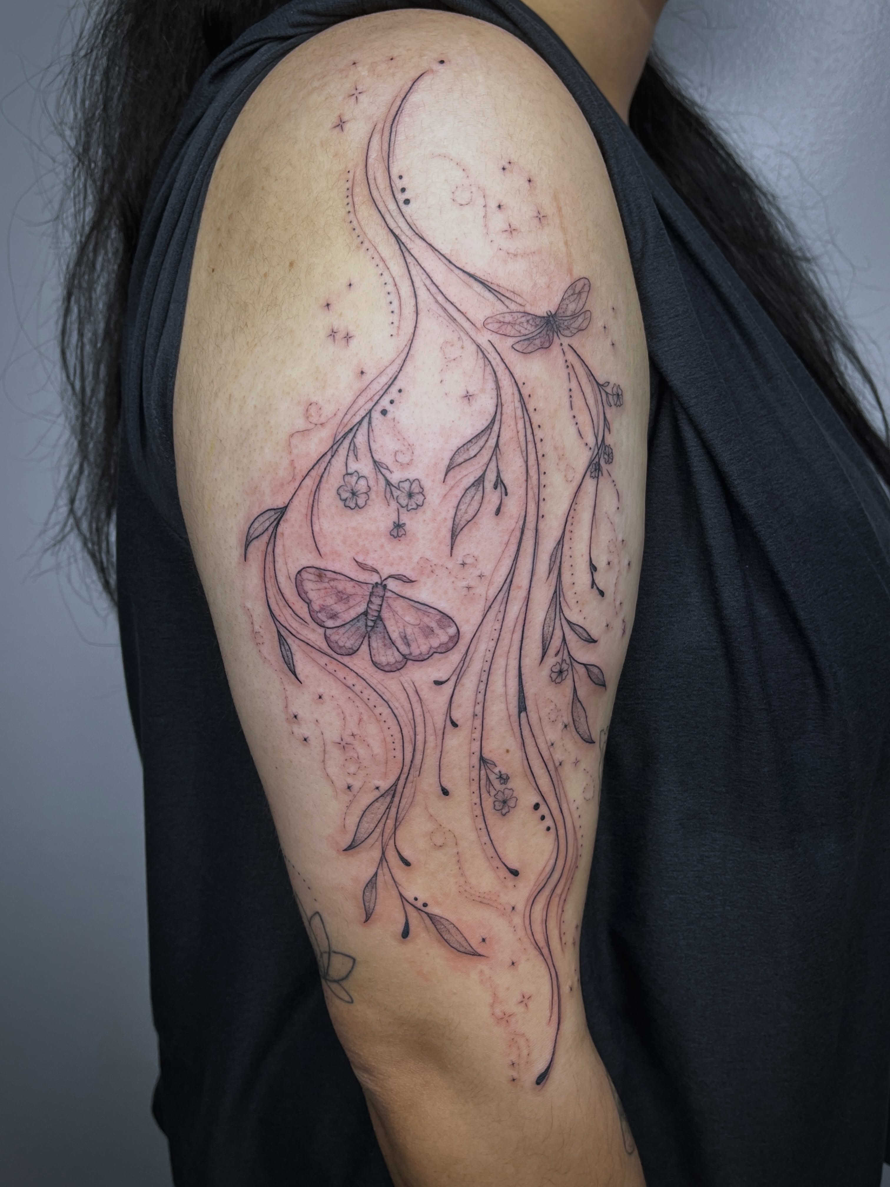 Butterfly and floral vines dotwork tattoo on the shoulder by Sid
