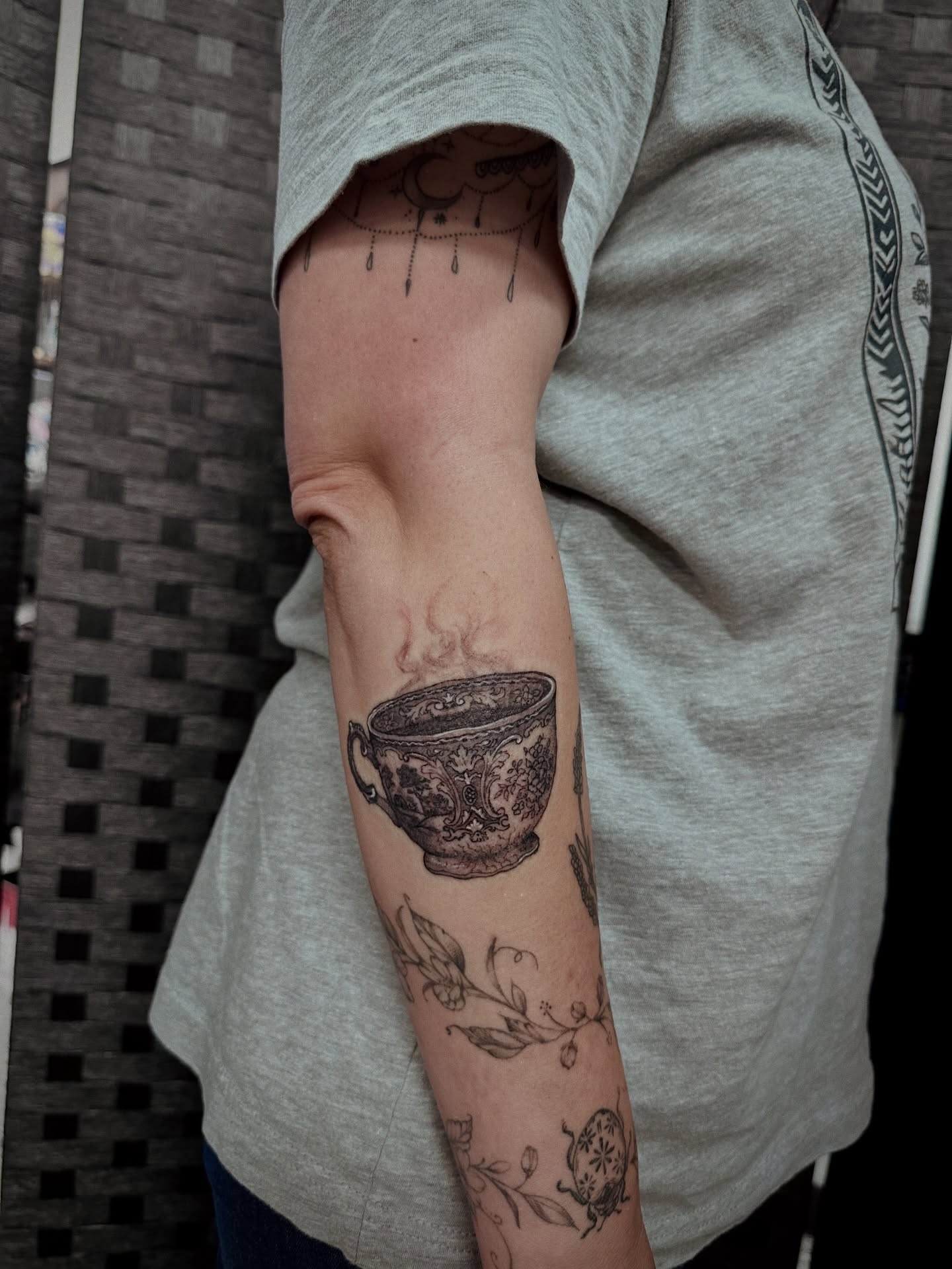 Steaming teacup black and grey tattoo on the forearm by Marlyn “Lala”