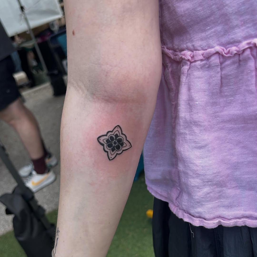 Geometric flower minimalist tattoo on the forearm by Miss Katie