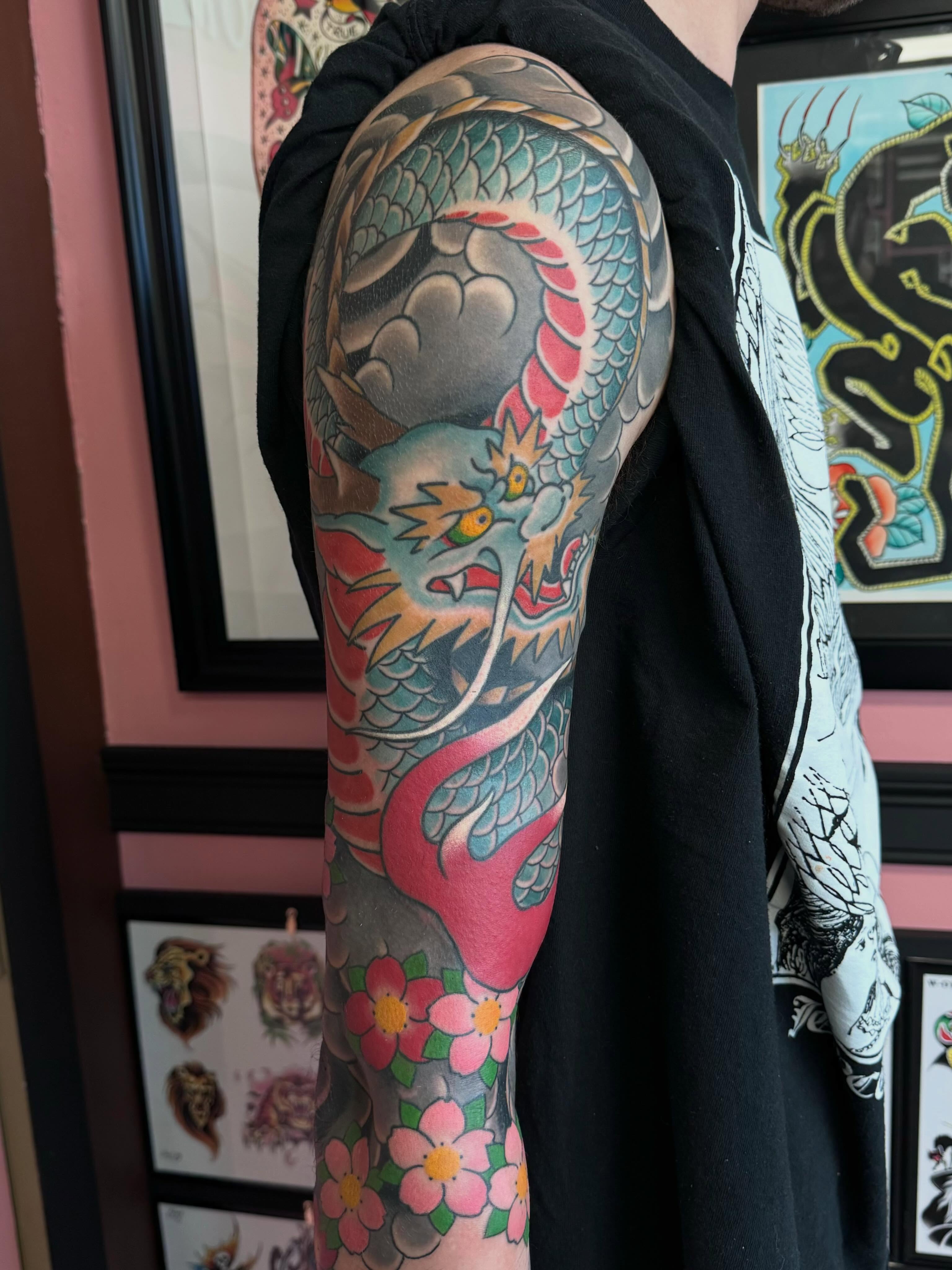 Dragon and flowers japanese irezumi tattoo on the upper arm by Landon Lewis