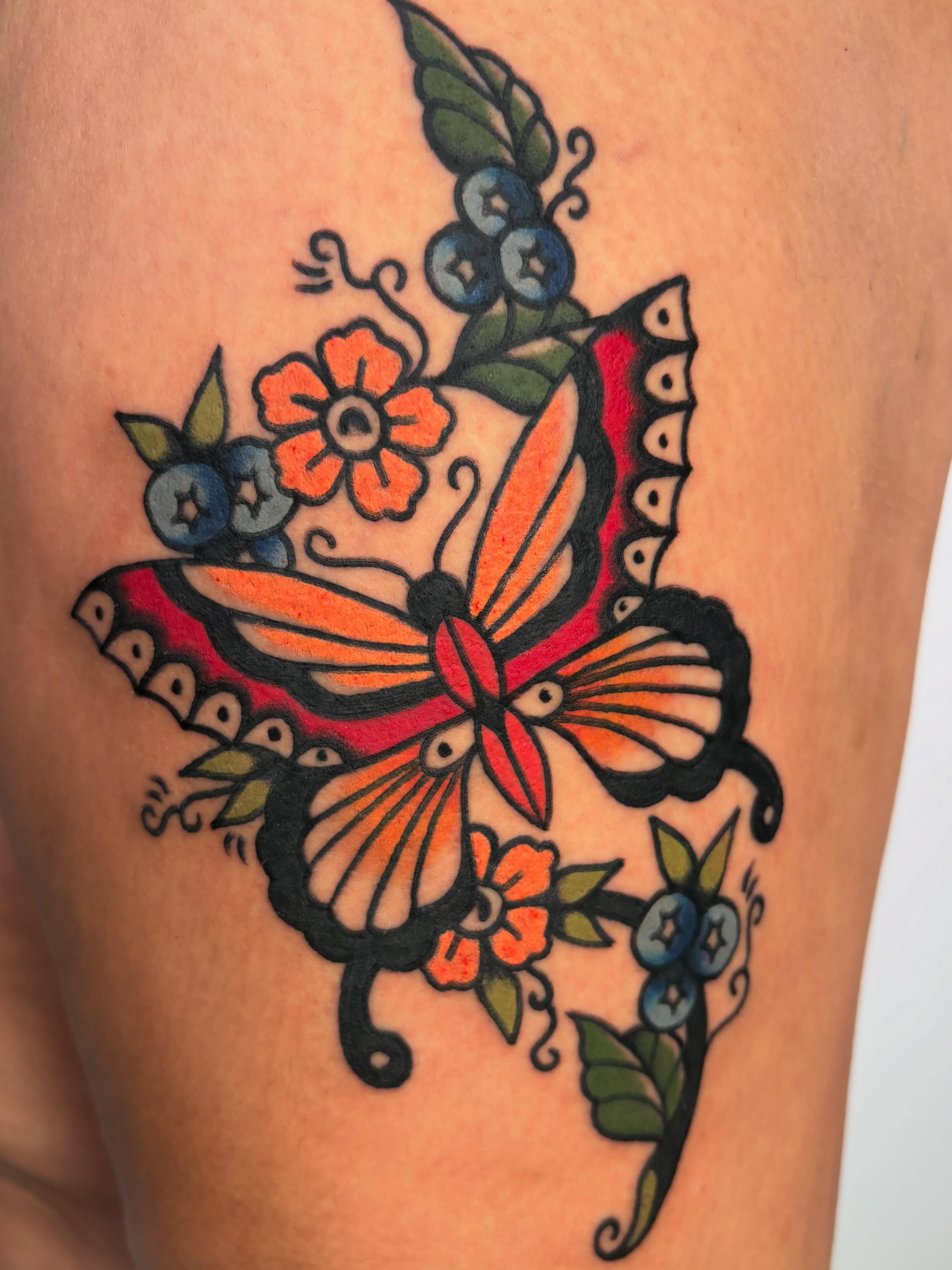 Butterfly and flowers American traditional tattoo on the thigh by Lorelei