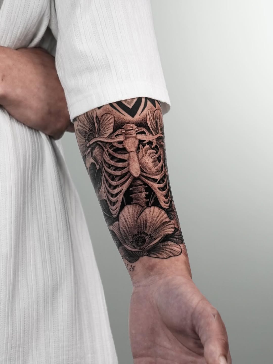 Ribcage and flowers realism tattoo on the forearm by Enrique Martinez
