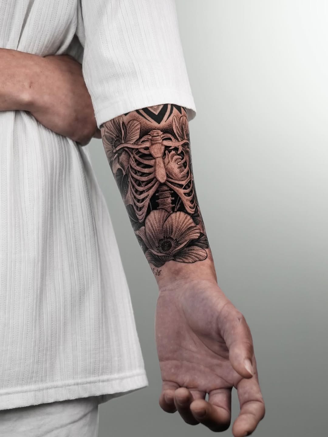 Ribcage and flowers realism tattoo on the forearm by Enrique Martinez