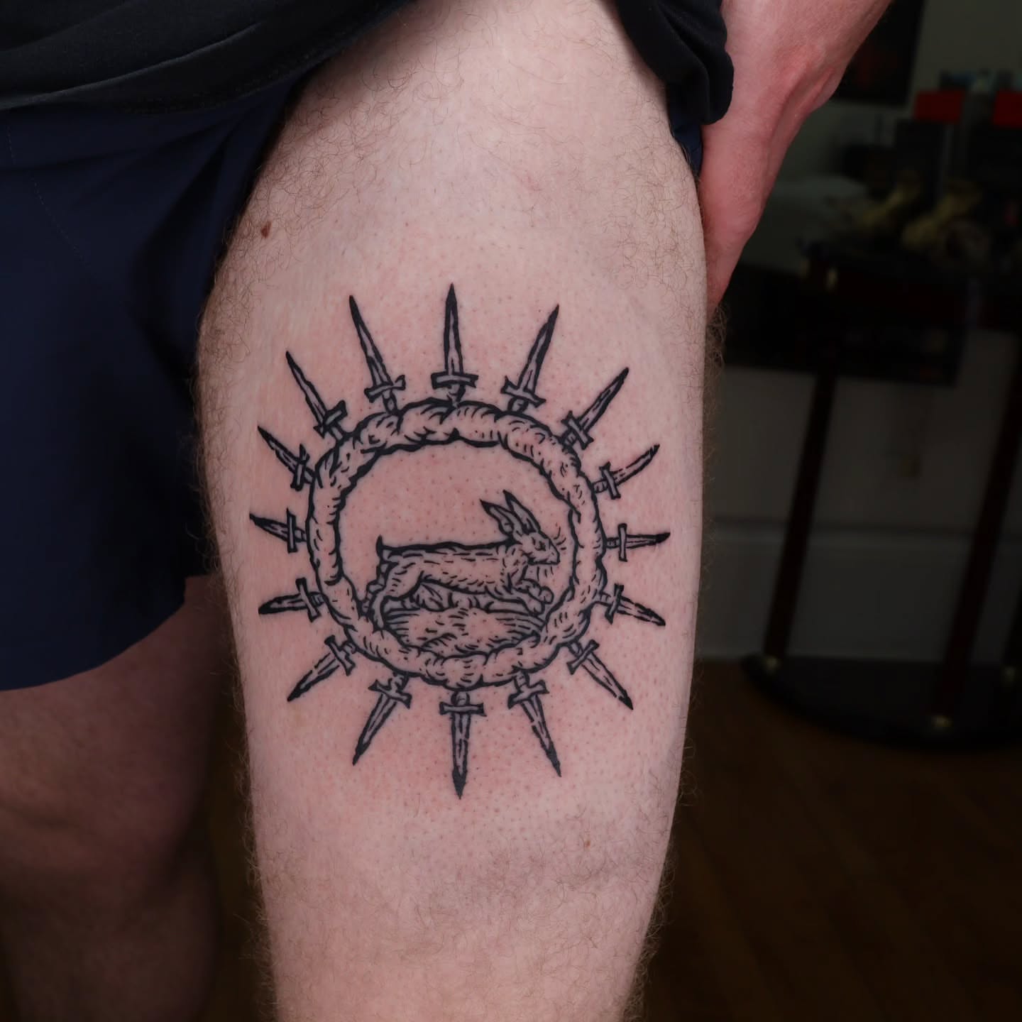 Rabbit and swords black and grey tattoo on the thigh by Veronika Lipchak
