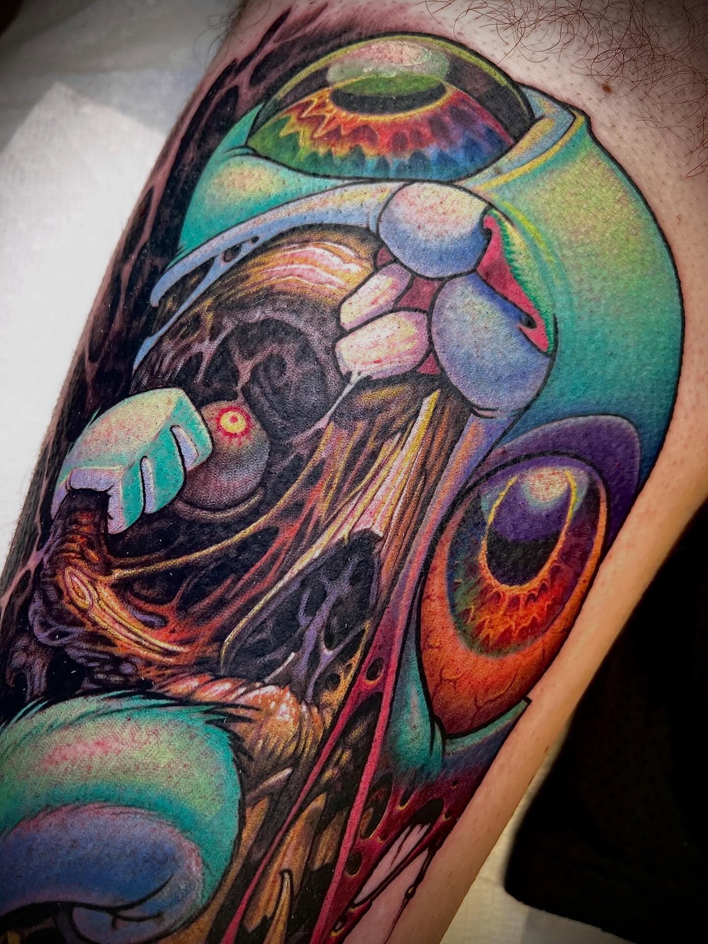 Abstract creature surrealism tattoo on the upper arm by Jesse Smith