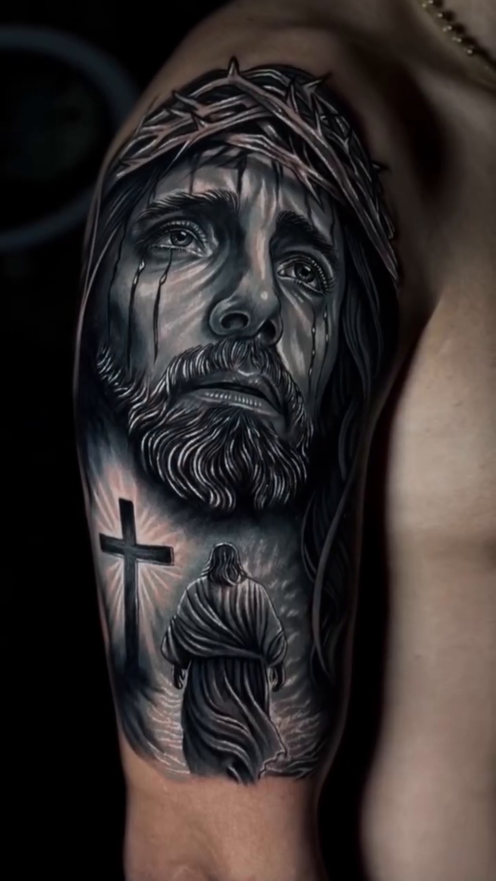 Jesus Christ with a cross Chicano tattoo on the upper arm by Francis nieves, Miami, Florida