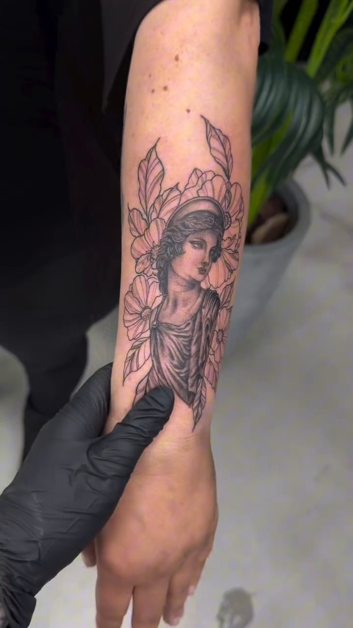 Portrait of a woman with flowers surrealism tattoo on the forearm by Lina Valentina, New York, New York