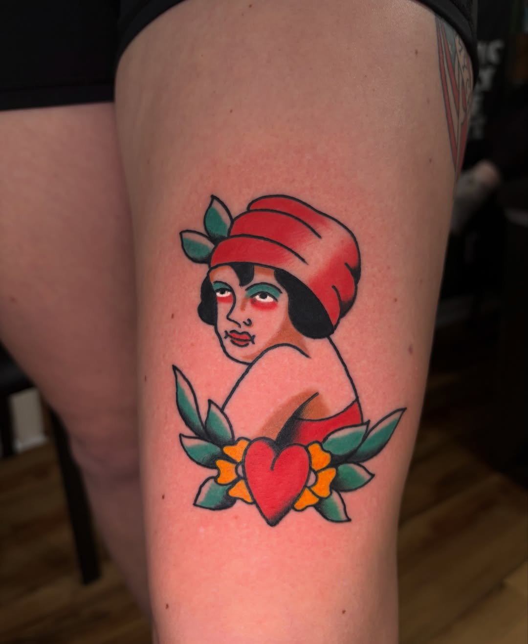 Flapper girl with heart American traditional tattoo on the thigh by Dustie Pitstick