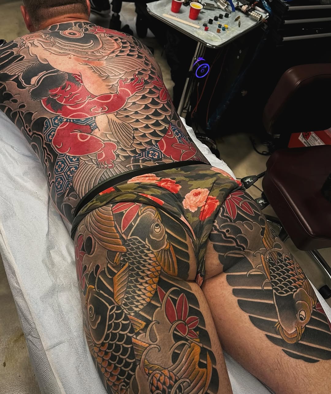 Koi fish and demon Japanese tattoo on the thigh by Xiaojun Yin, Vancouver, British Columbia