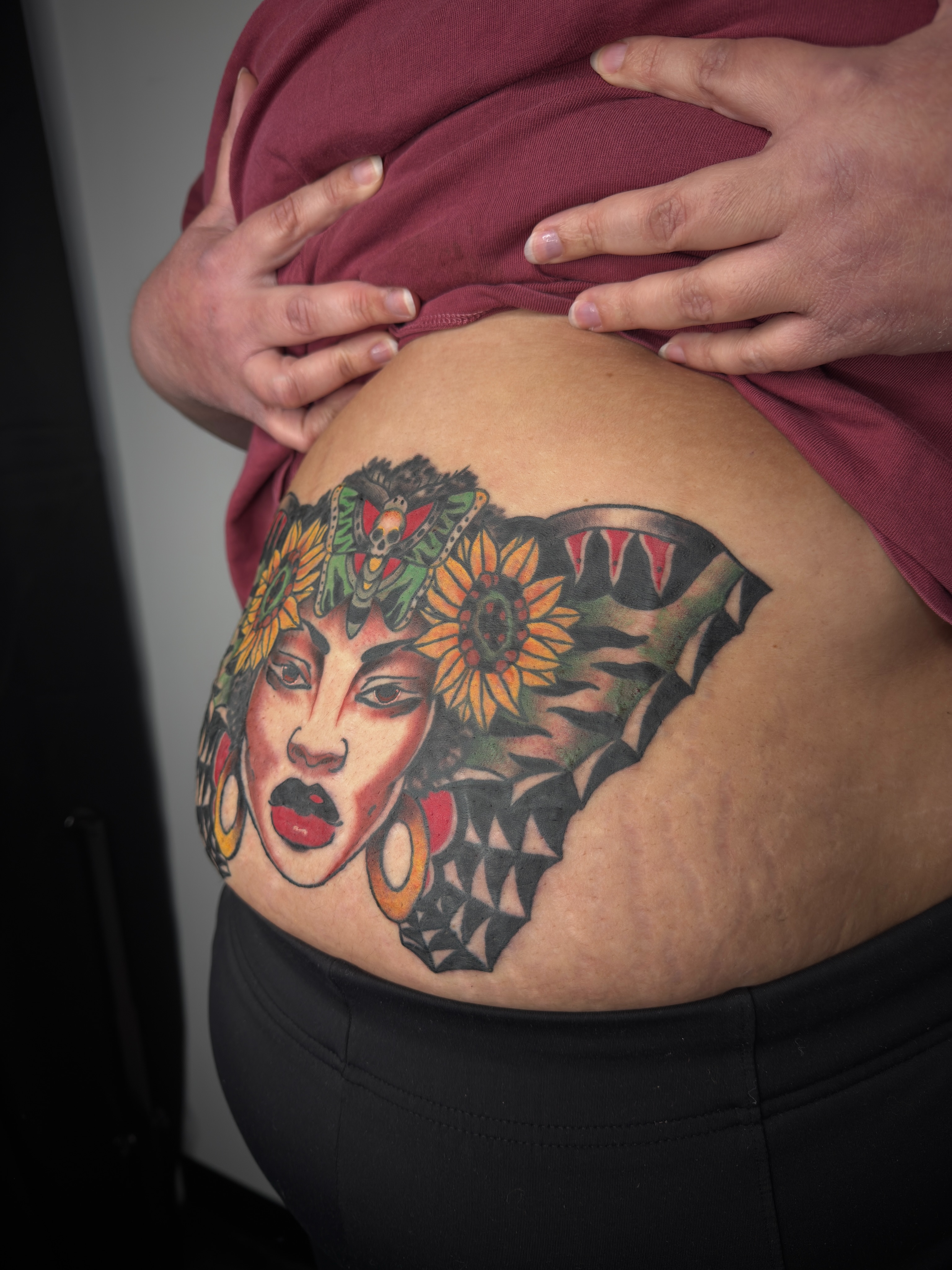 Woman with sunflowers American traditional tattoo on the torso by Joshua Carter