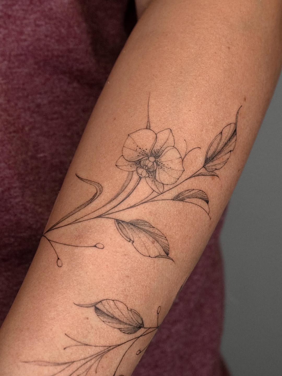 Orchid and leaves fine line tattoo on the forearm by ๐๐๐ฆ ๐๐ ๐ฎ๐ฒ๐๐ง
