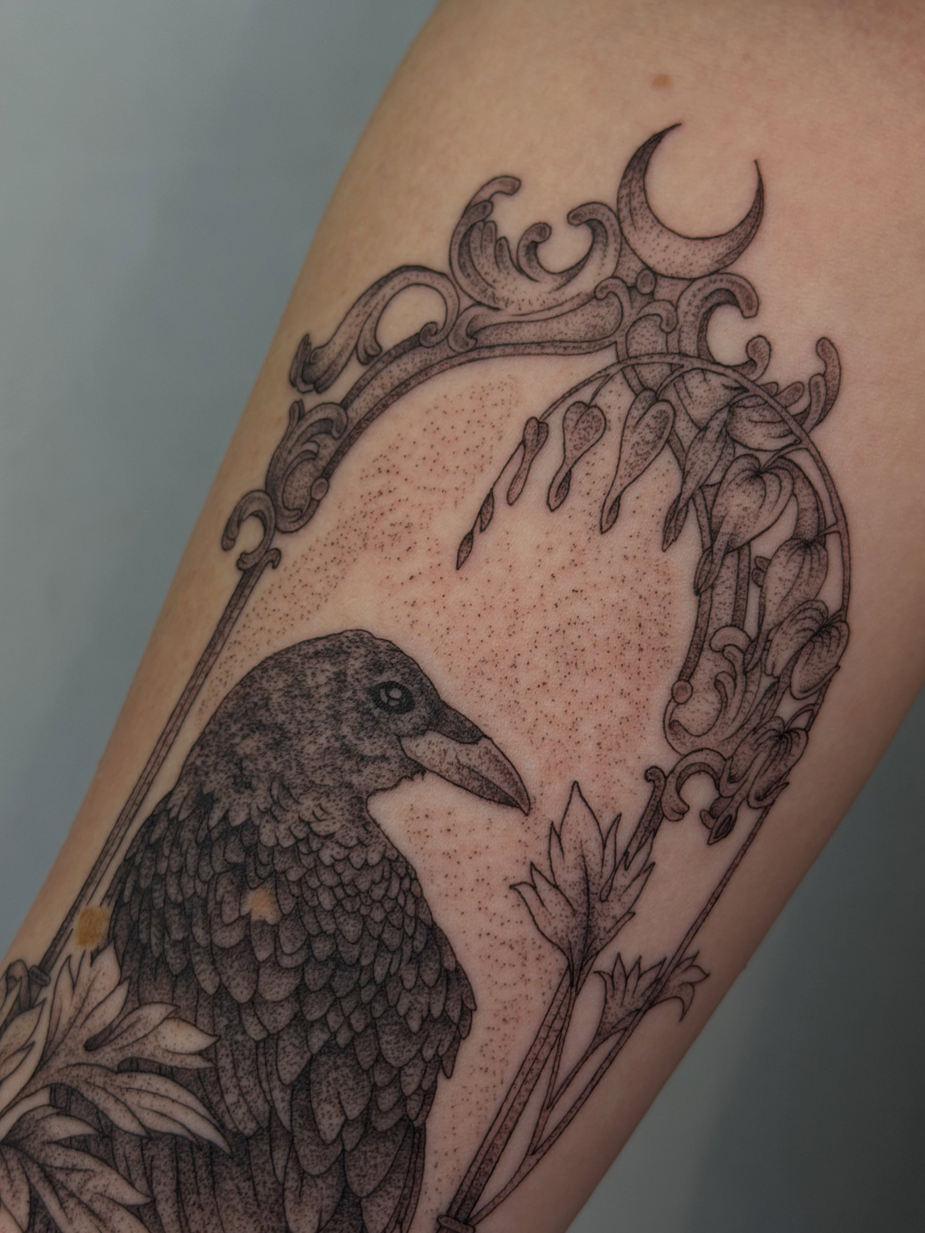 Crow and floral frame dotwork tattoo on the forearm by Henesee Parfitt