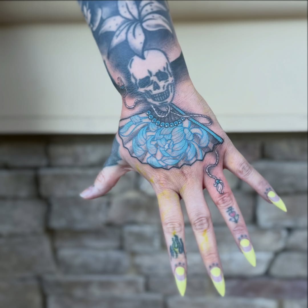 Skull and floral dress American traditional tattoo on the hand by ⛓️ 𝓑𝓻𝓸𝓸𝓴𝓮𝓵𝓵𝓮 𝓑𝓸𝓶𝓫𝓼𝓱𝓮𝓵𝓵𝓮 ⛓️