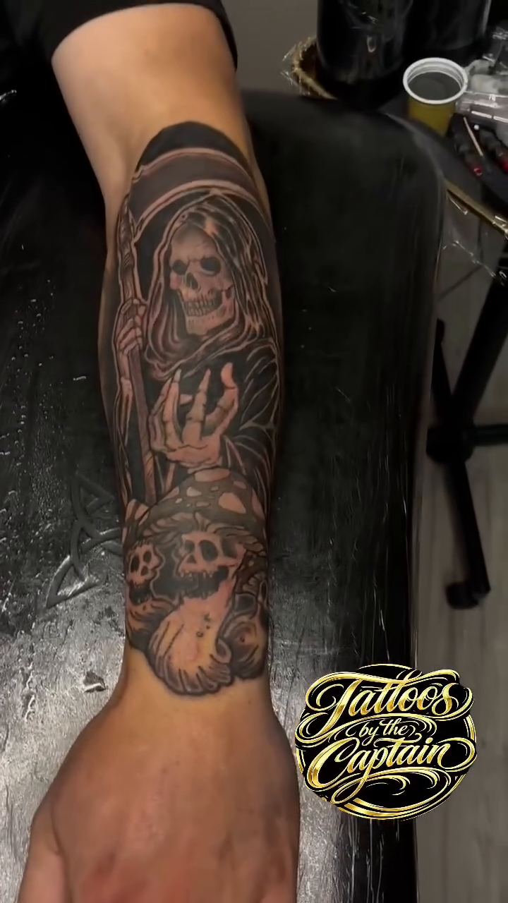 Grim Reaper with skulls realism tattoo on the forearm by Captain Michael Devious