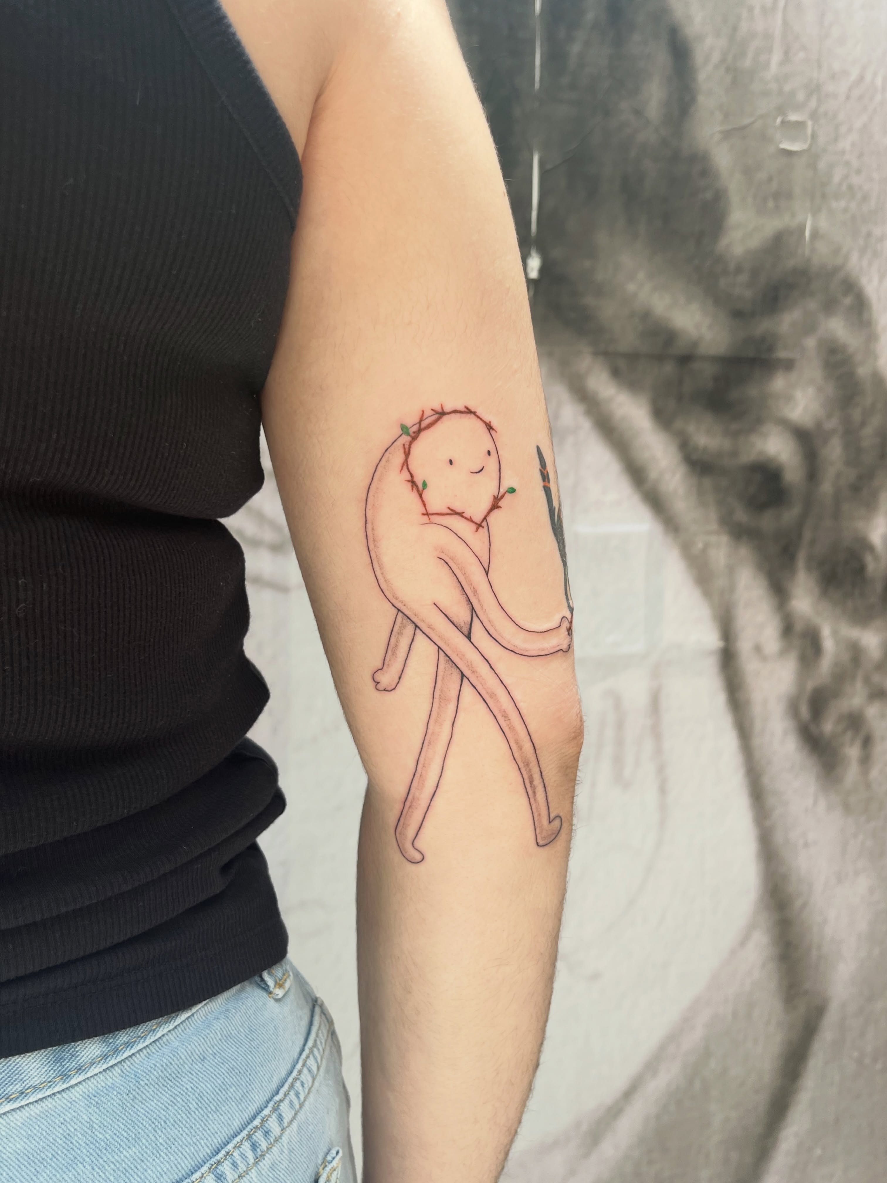 Child-like figure minimalist tattoo on the forearm by Kyra Monterrosa