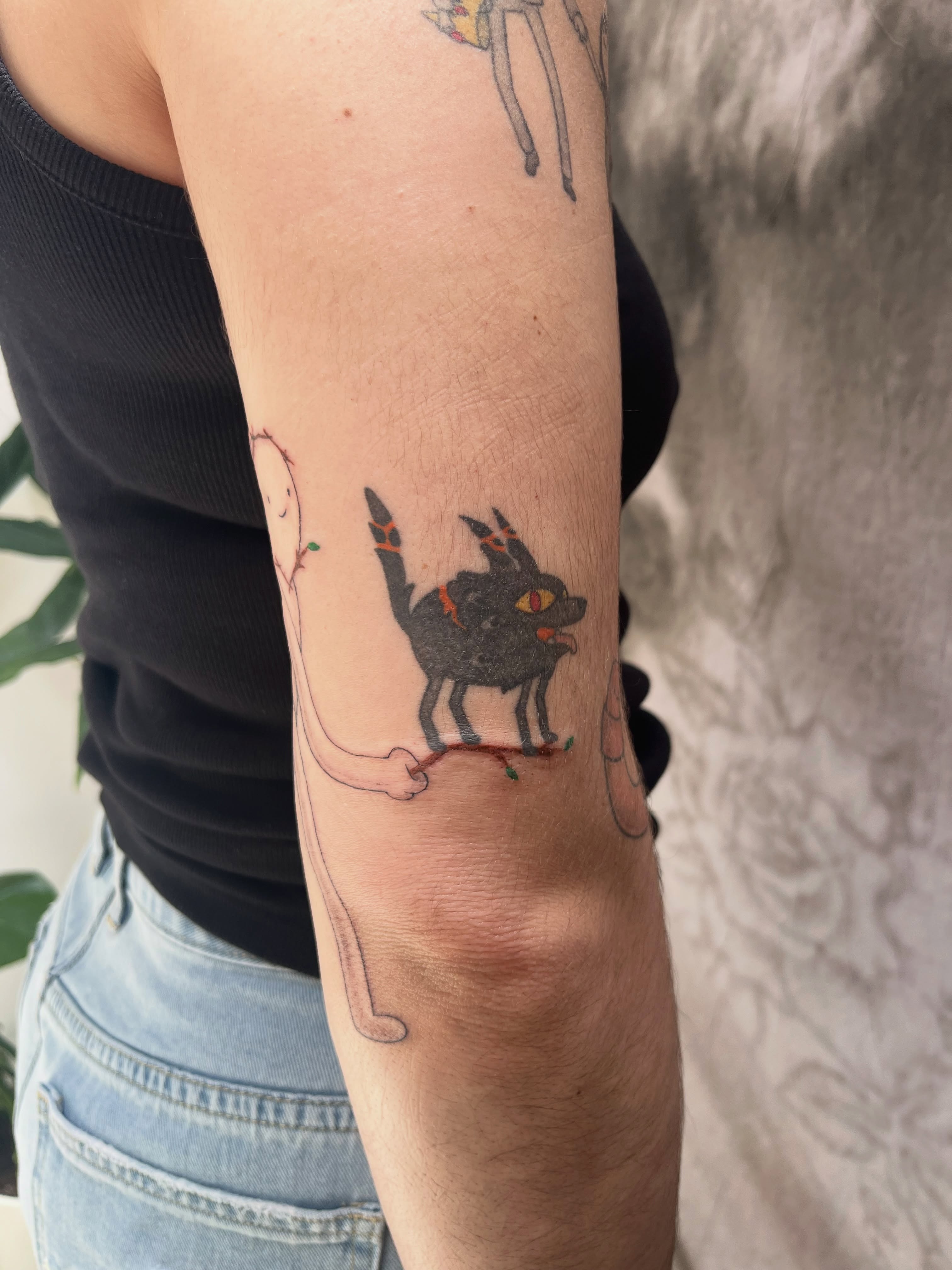 Cat and ghost dotwork tattoo on the forearm by Kyra Monterrosa