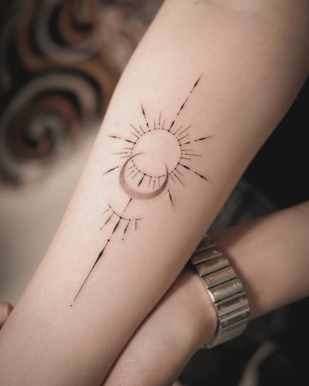 Sun and moon abstract ornamental tattoo on the forearm by Easy