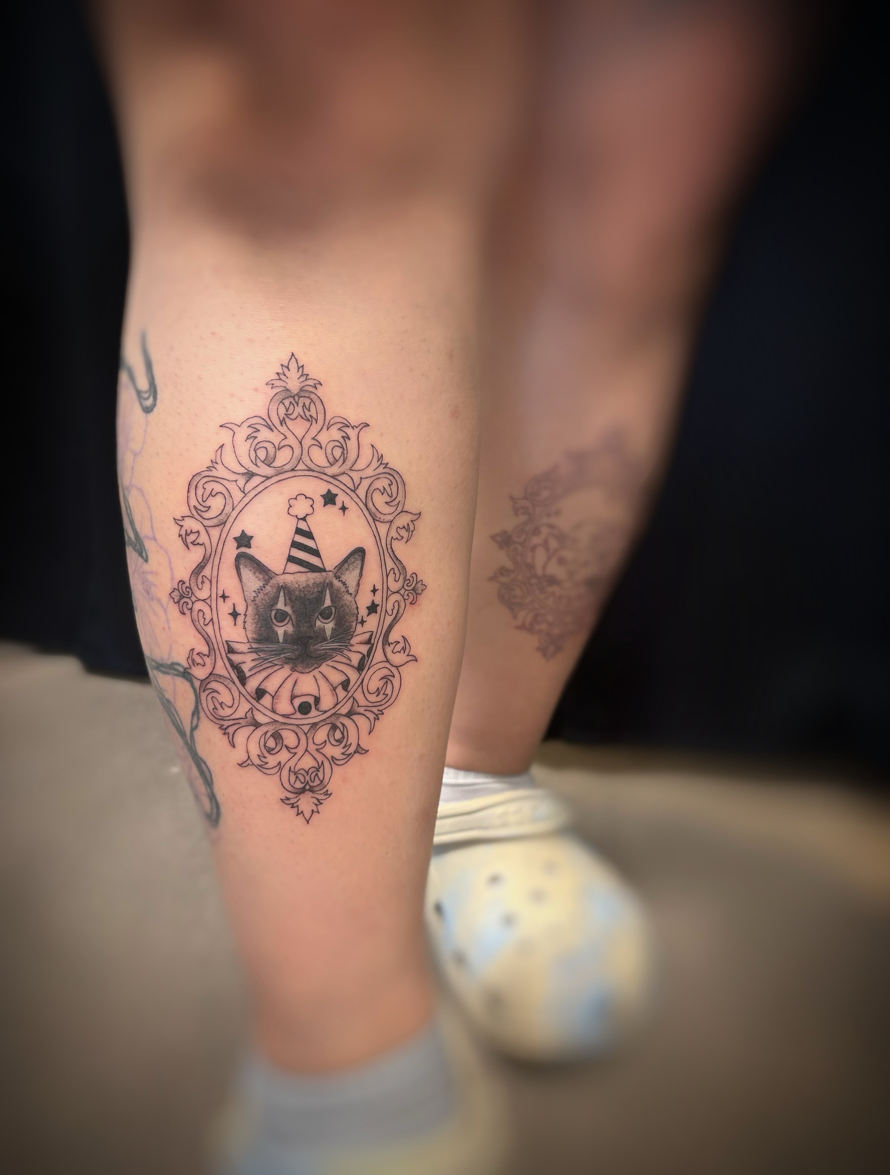 Cat in a circus ring black and grey tattoo on the leg by Holly