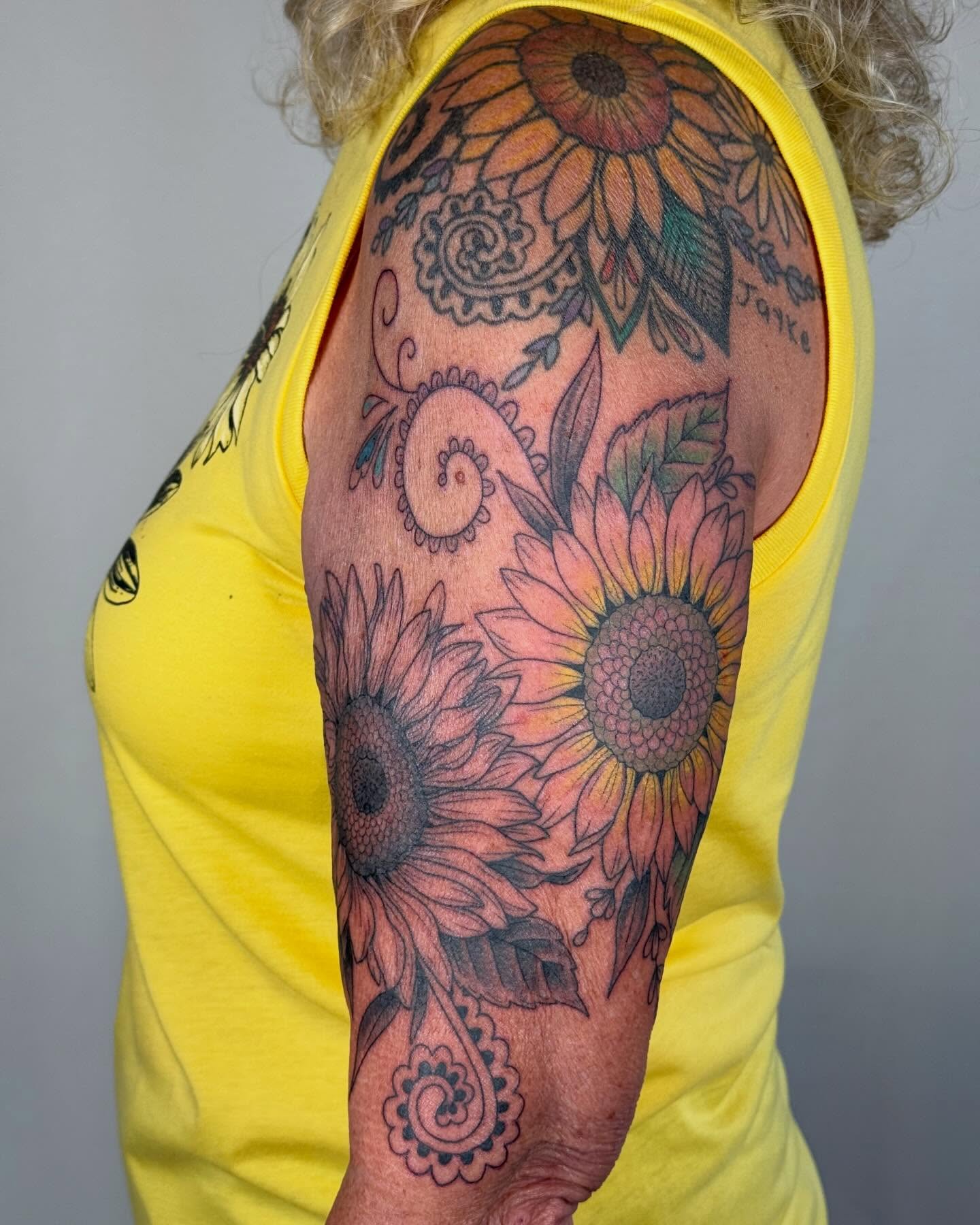 Sunflowers black and grey tattoo on the upper arm by Larkin Resler