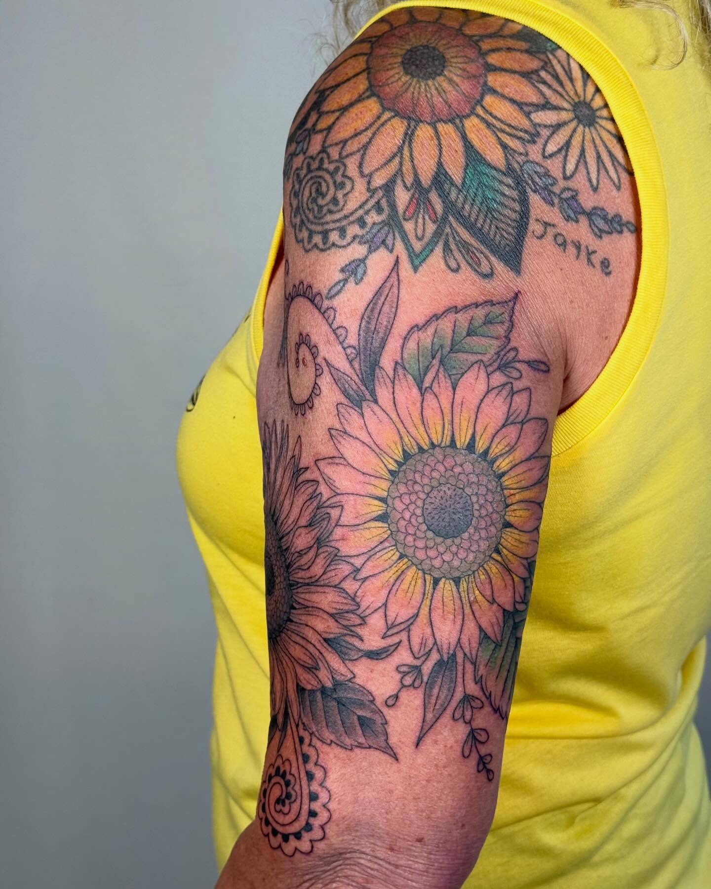 Sunflower dotwork tattoo on the upper arm by Larkin Resler