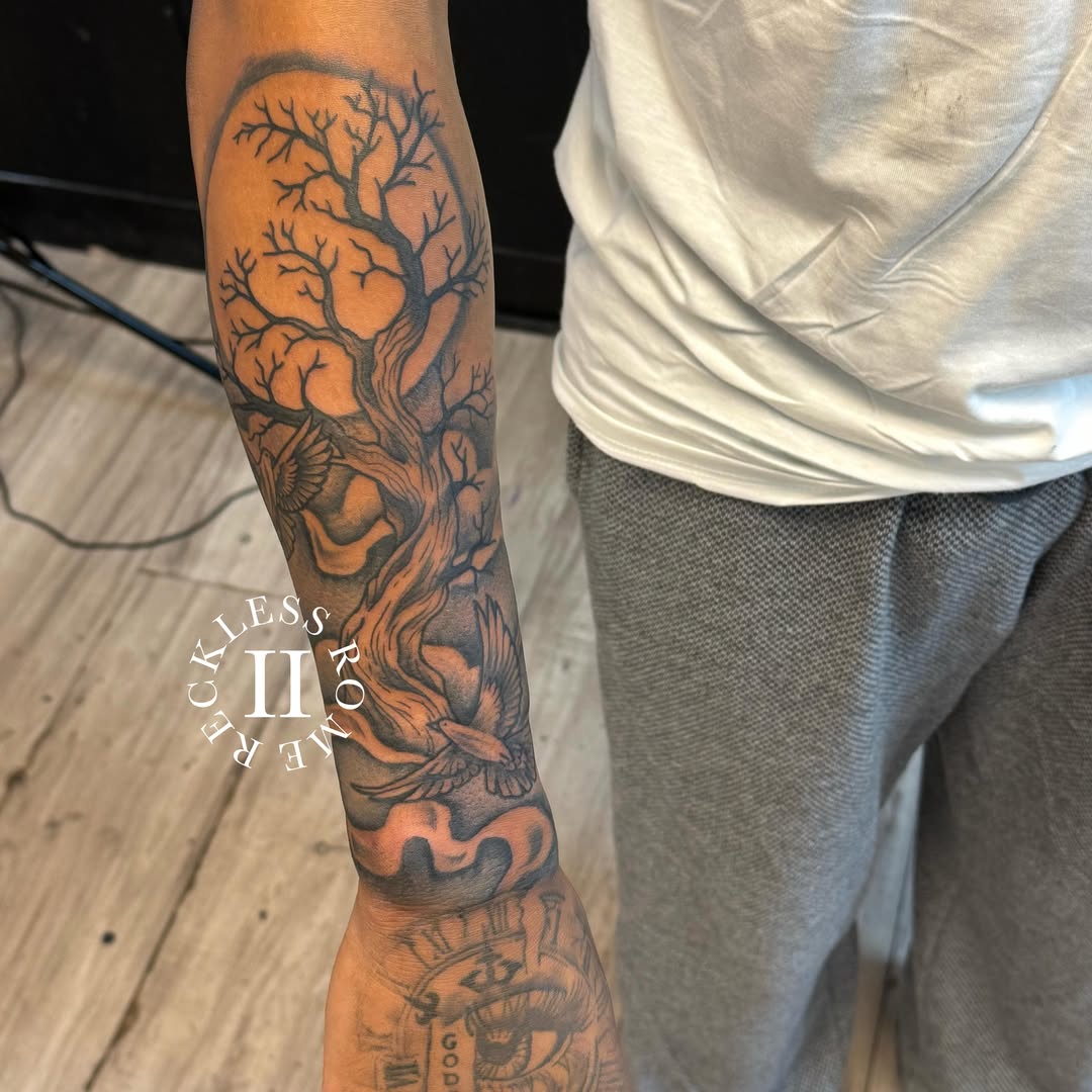Tree and bird realism tattoo on the forearm by Rome