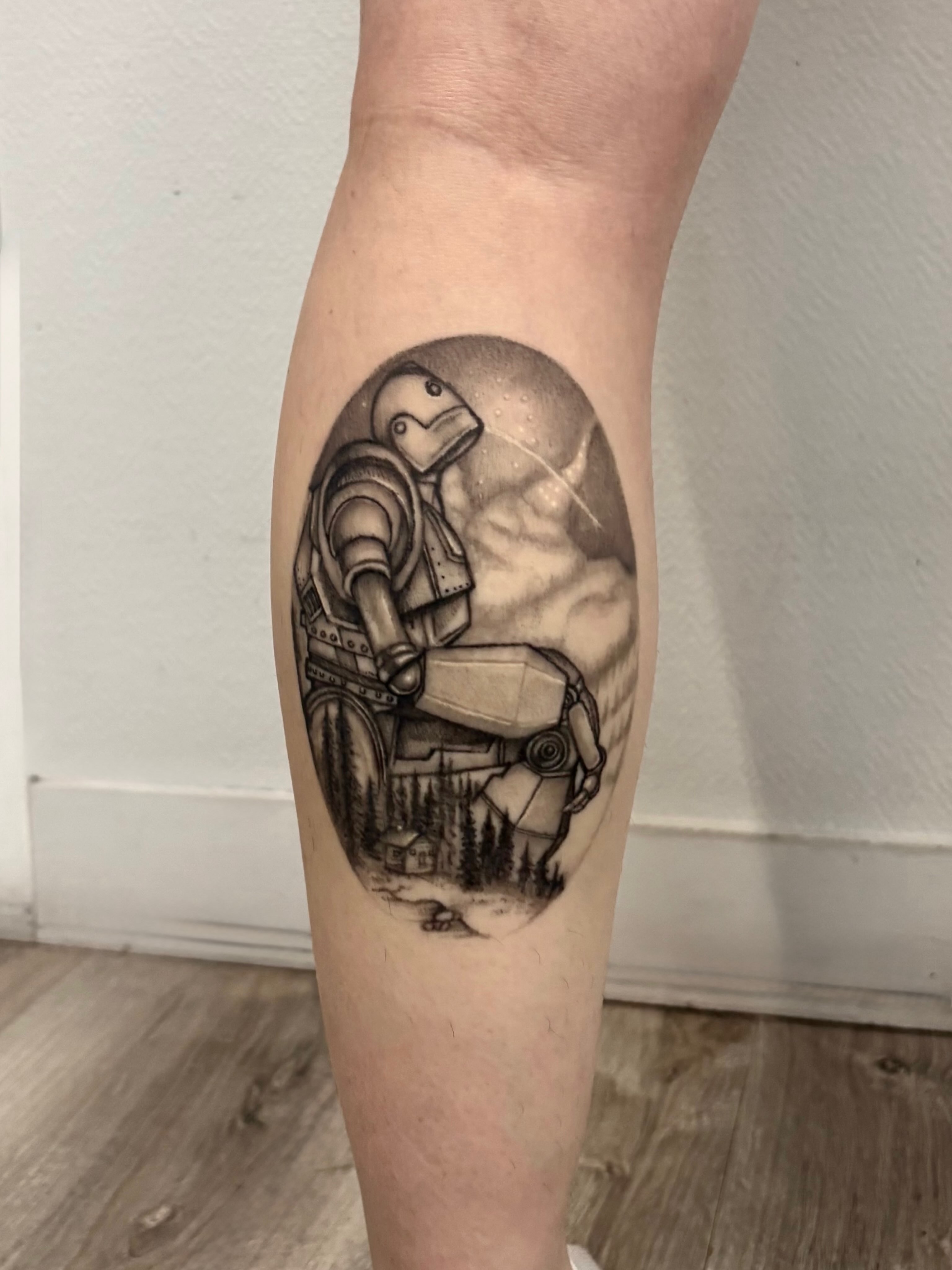 Robot in landscape realism tattoo on the forearm by Deborah