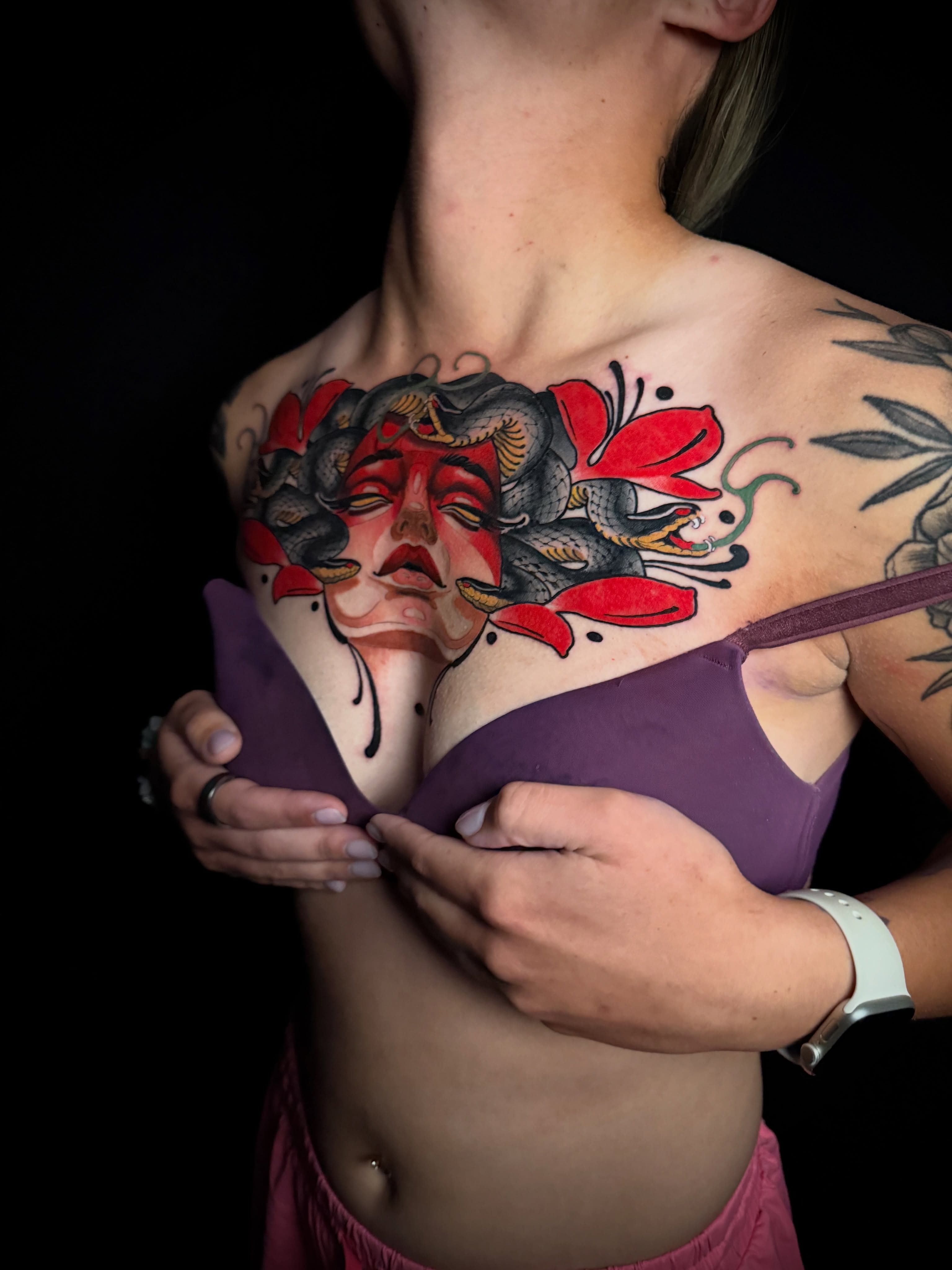 Woman's face with snake and flowers American traditional tattoo on the chest by Brad Snow