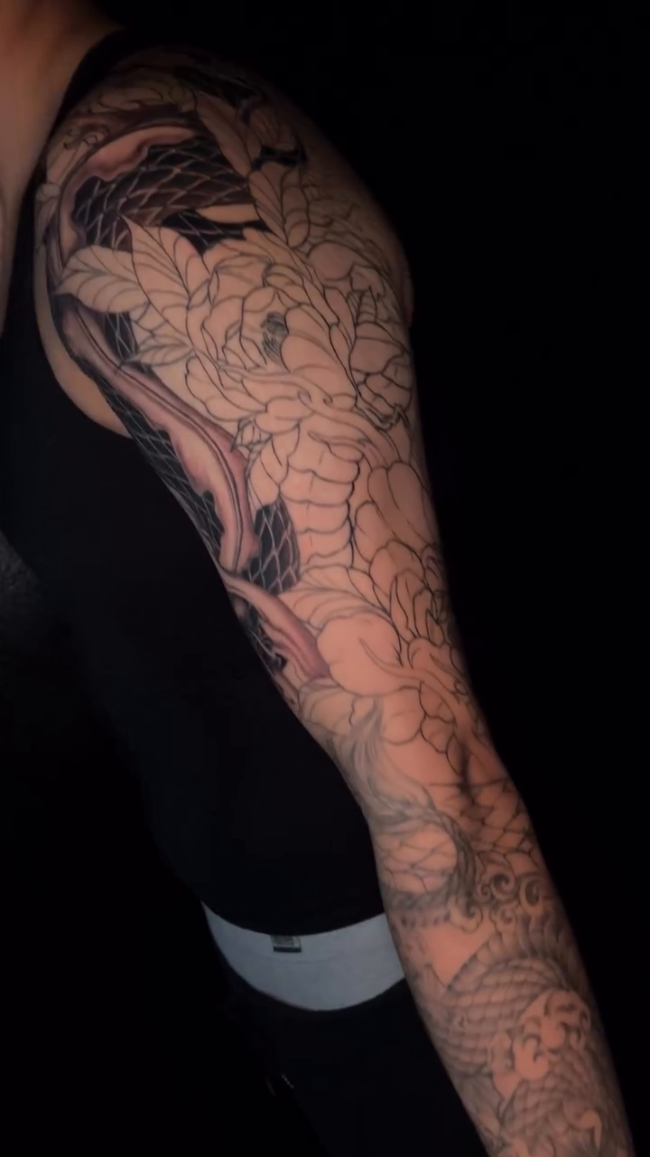 Koi fish with floral elements Japanese tattoo on the upper arm by bev