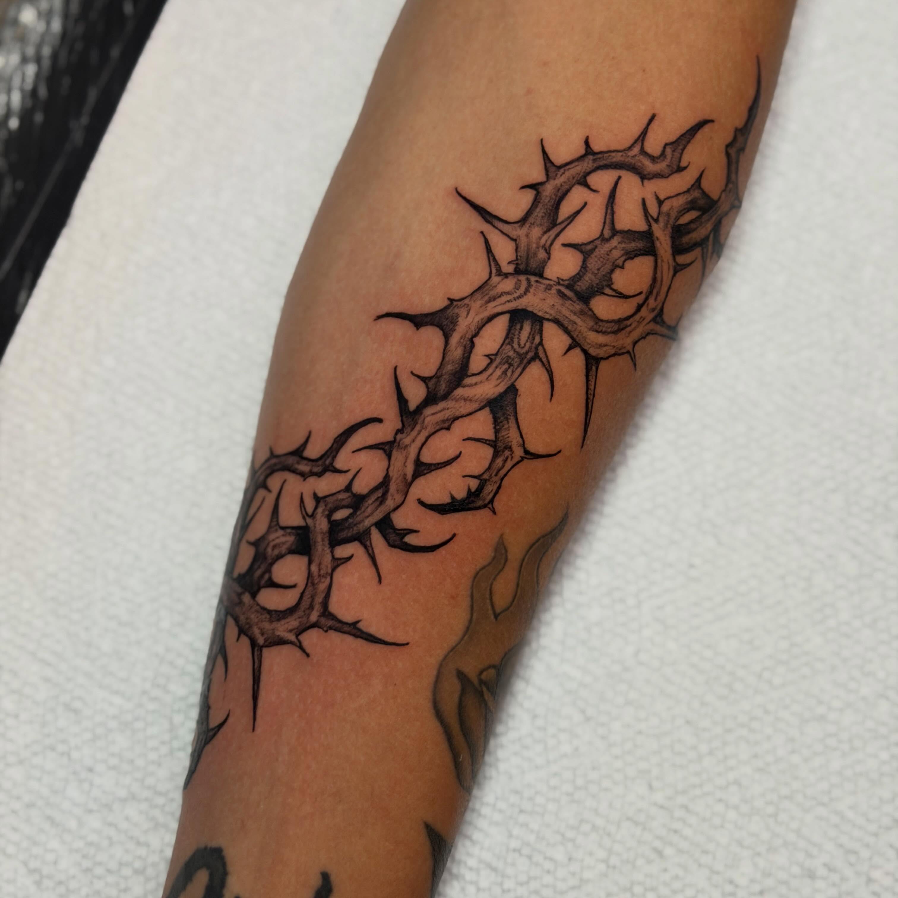 Crown of thorns black and grey tattoo on the forearm by Adam Newton