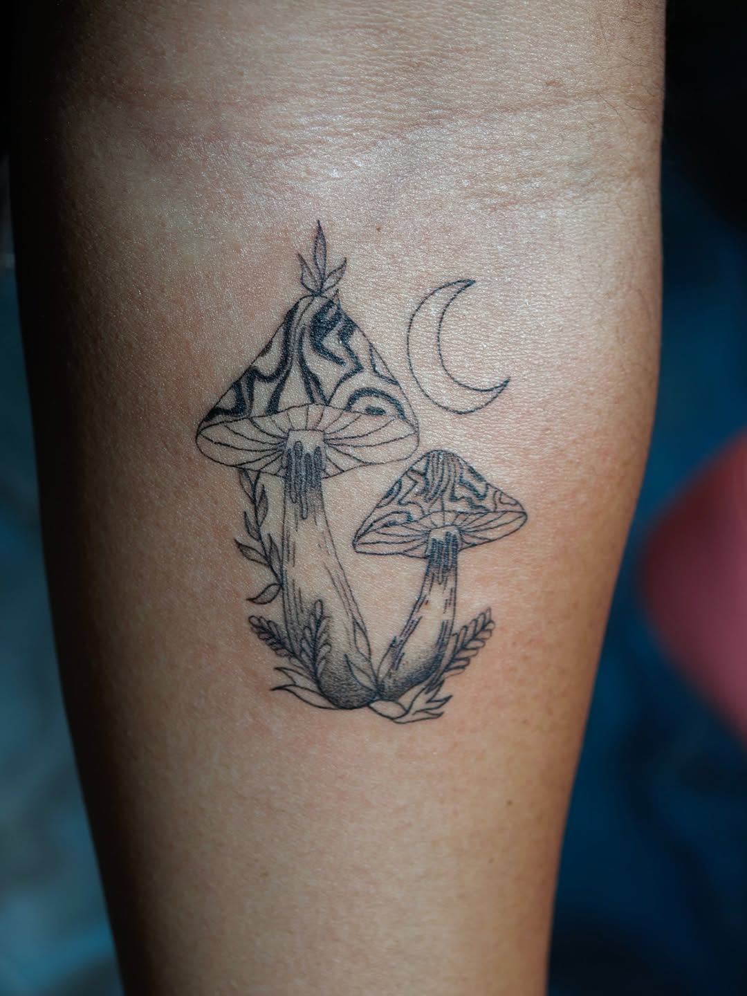 Mushrooms and moon dotwork tattoo on the forearm by Dani Sandoval, Anaheim, California